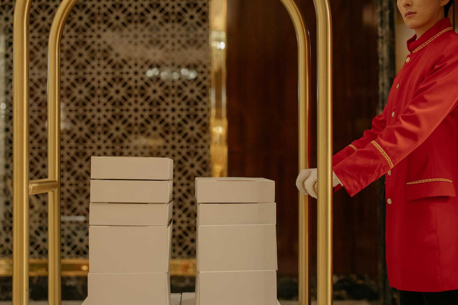 Un employé d'hôtel poussant un chariot avec des boîtes | Source : Pexels