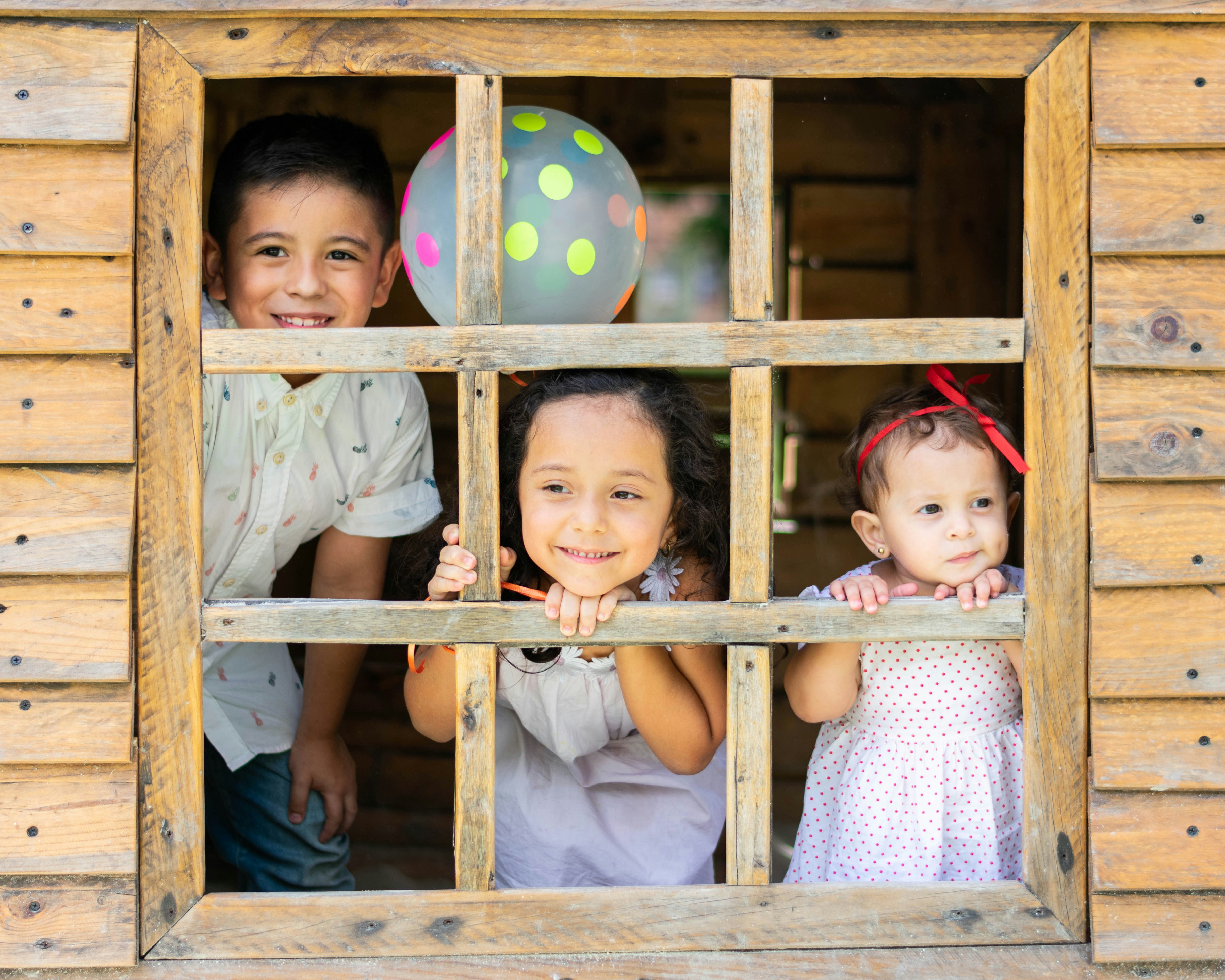 Des enfants à la fenêtre d'une cabane | Source : Unsplash