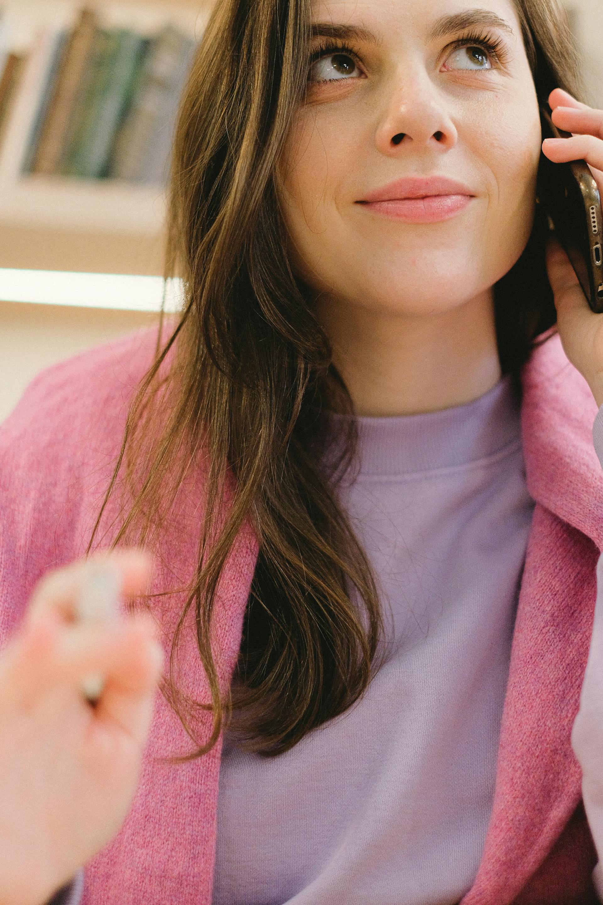 Une femme souriant d'un air maussade pendant un appel téléphonique | Source : Pexels