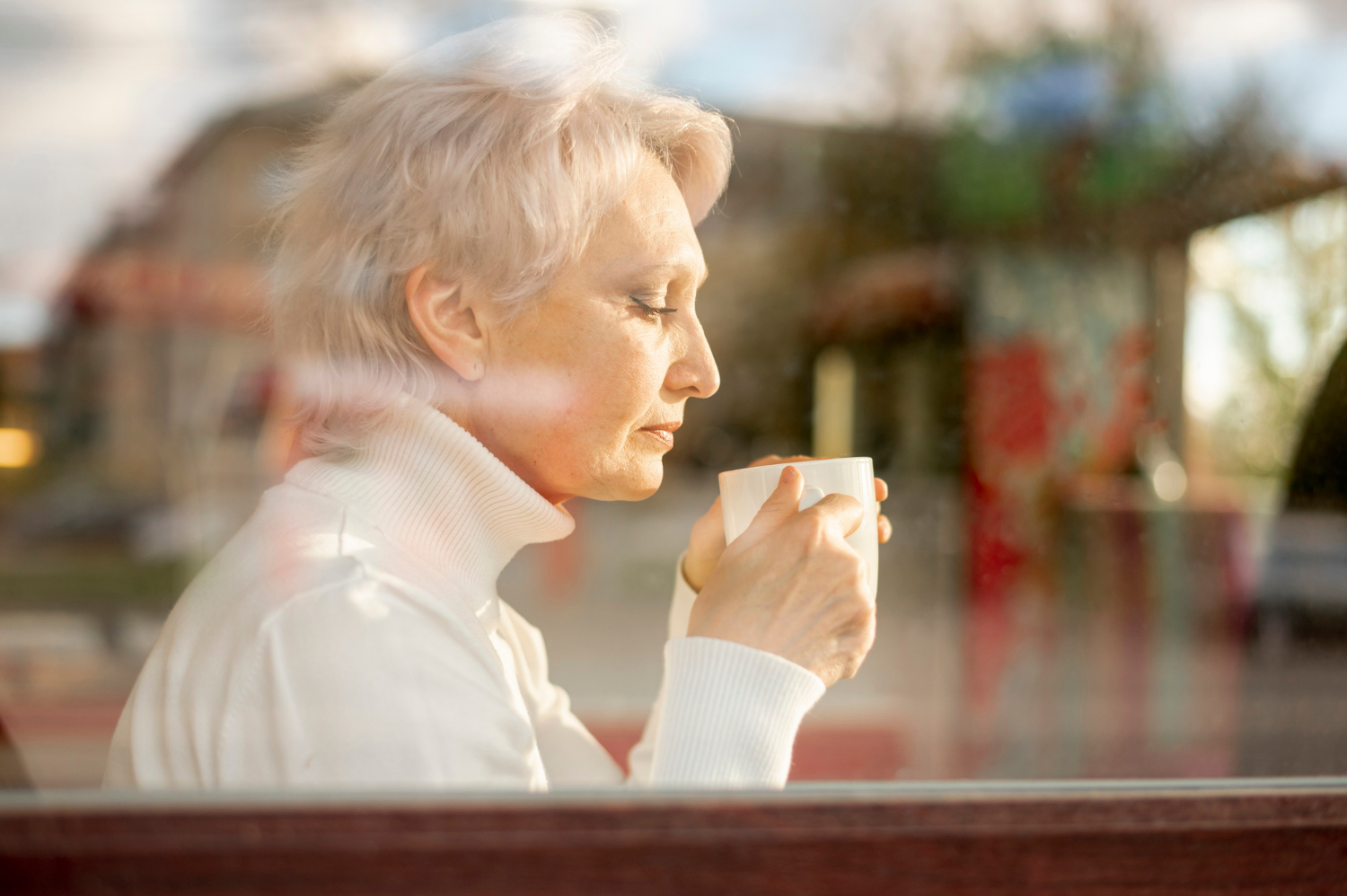 Une femme âgée tenant une tasse en céramique blanche | Source : Freepik
