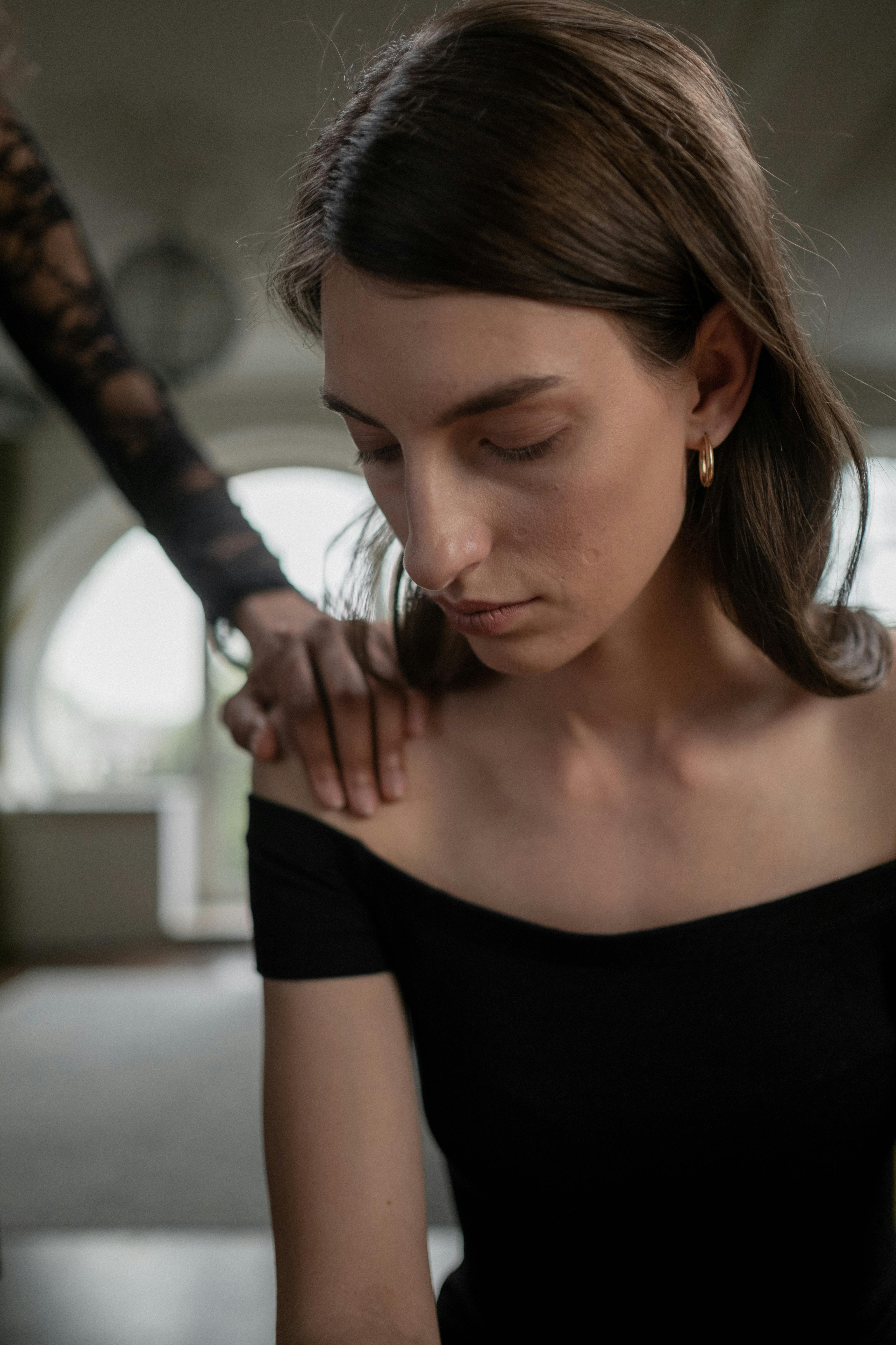 Une femme triste faisant face à la réalité tout en étant réconfortée | Source : Pexels