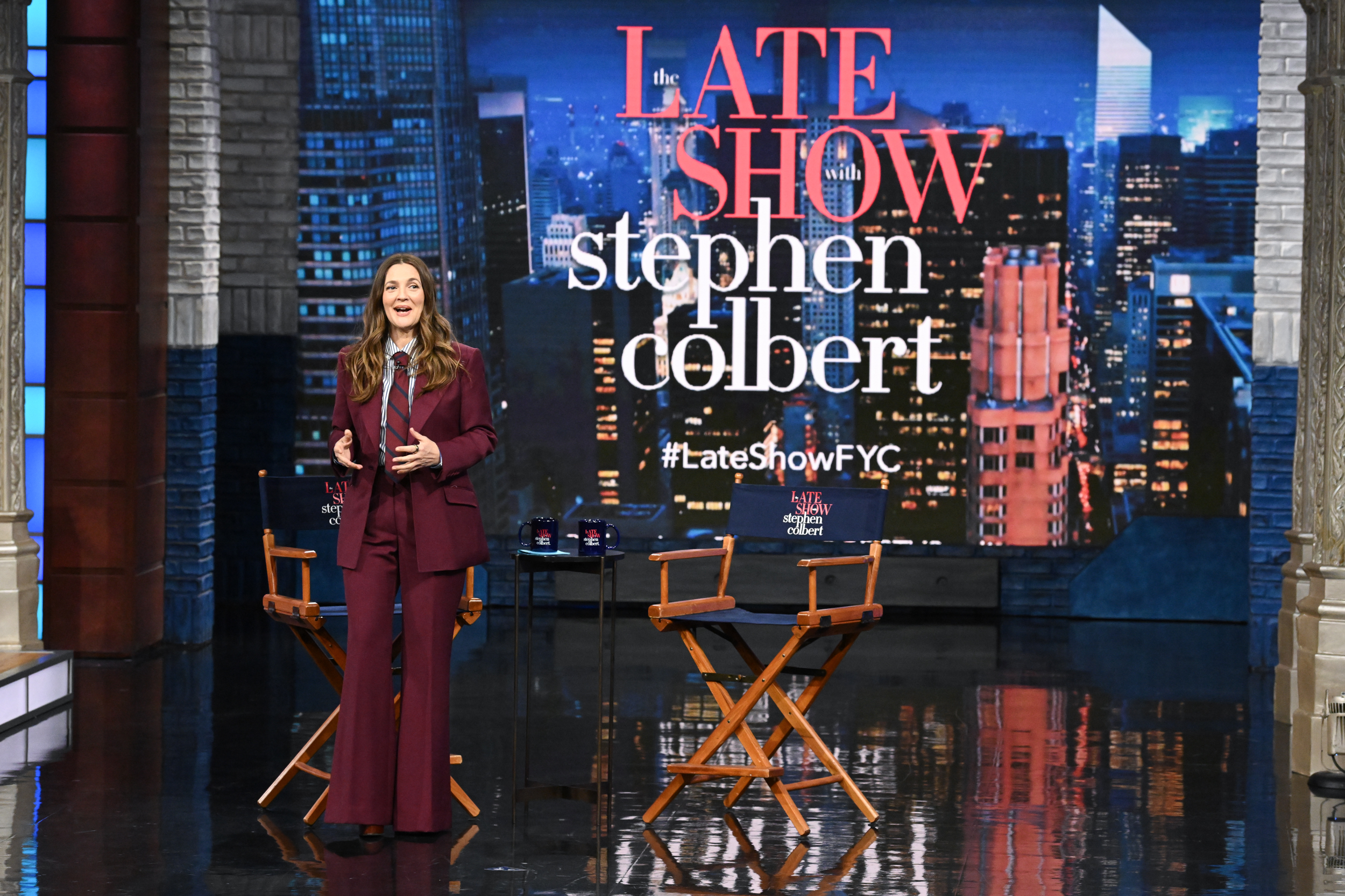 Drew Barrymore dans un tailleur bordeaux impeccable alors qu'elle anime "The Late Show with Stephen Colbert" le 1er mai 2025.