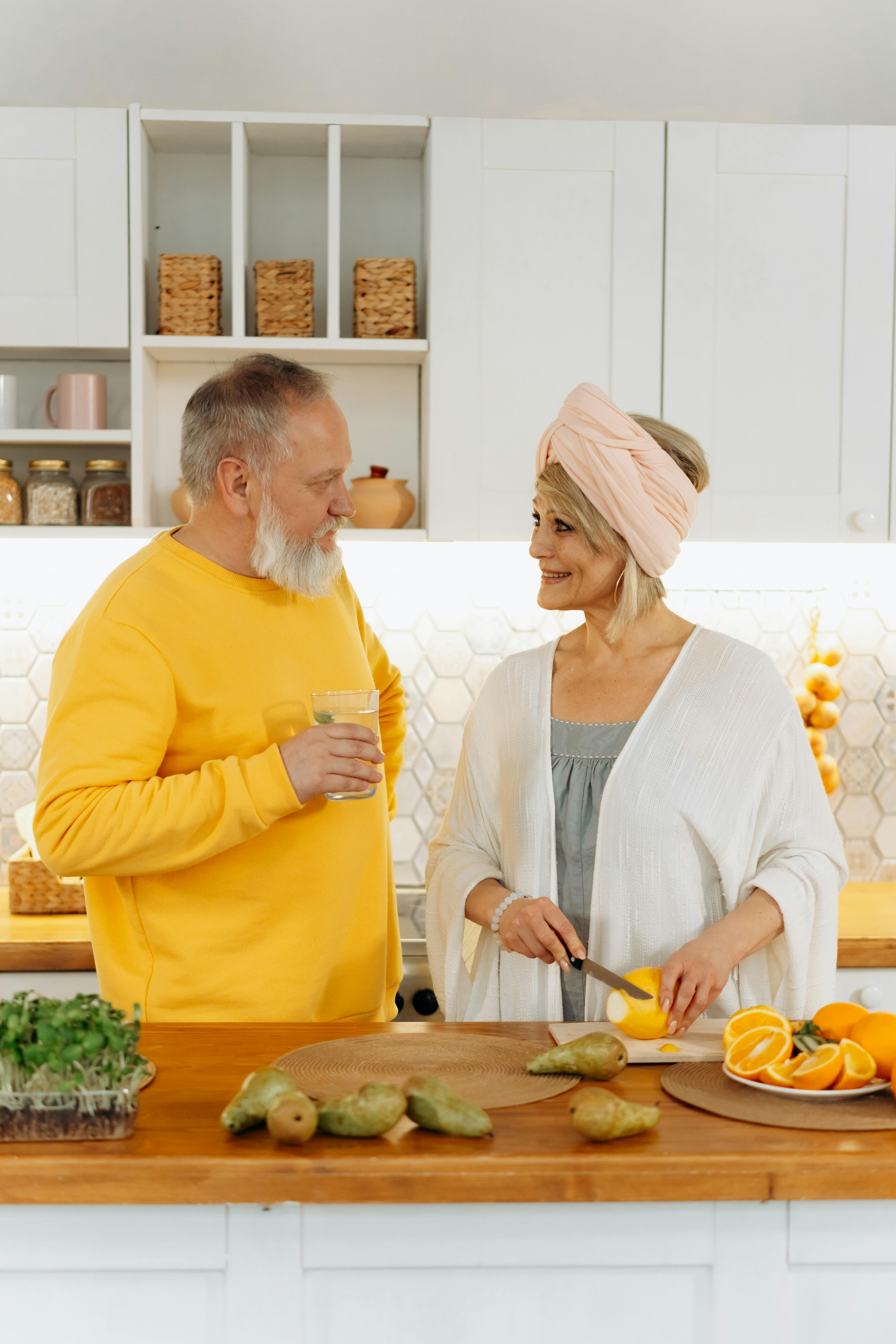 Un couple âgé souriant dans une cuisine | Source : Pexels