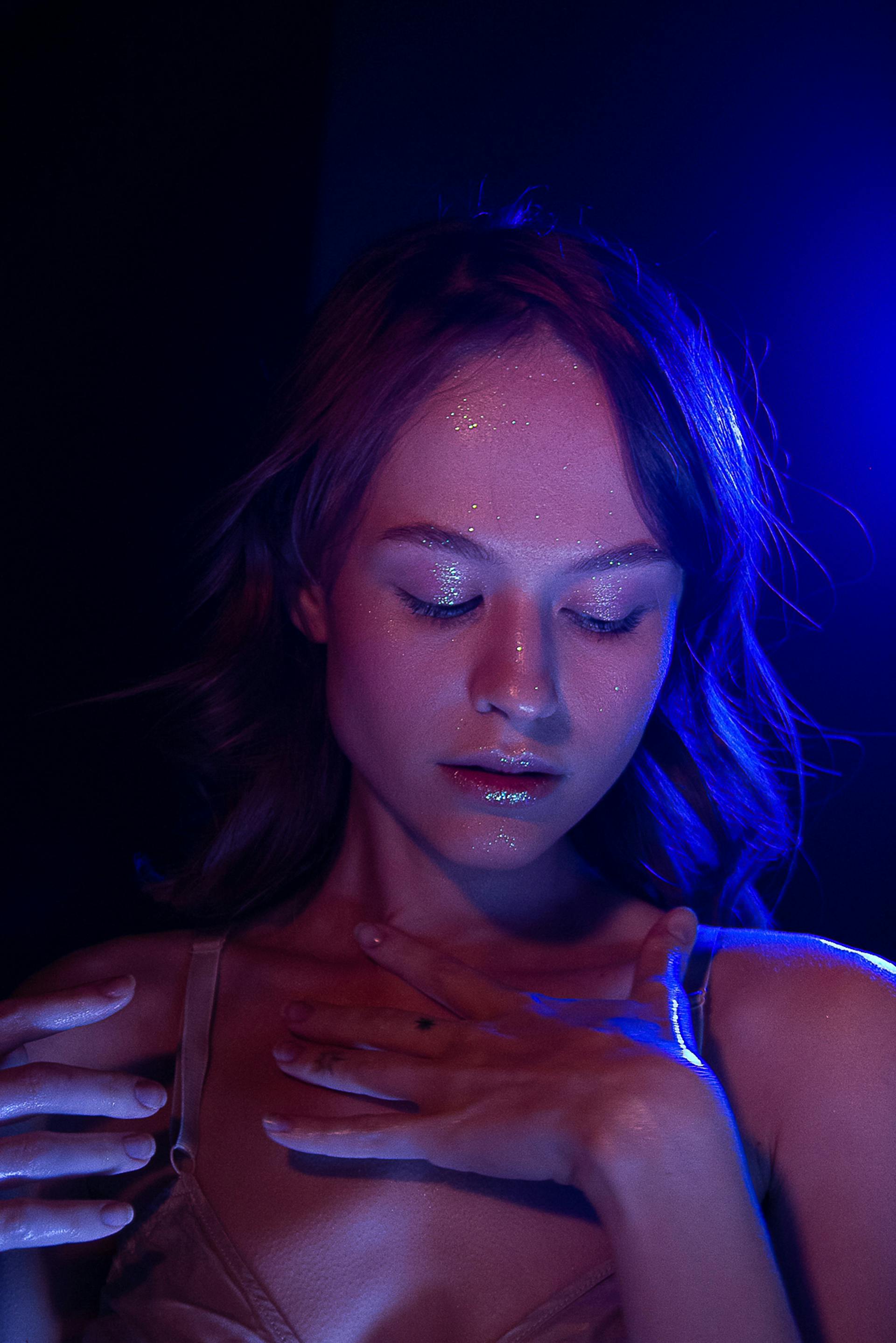 Une femme regardant vers le bas avec des paillettes sur son visage Source : Pexels