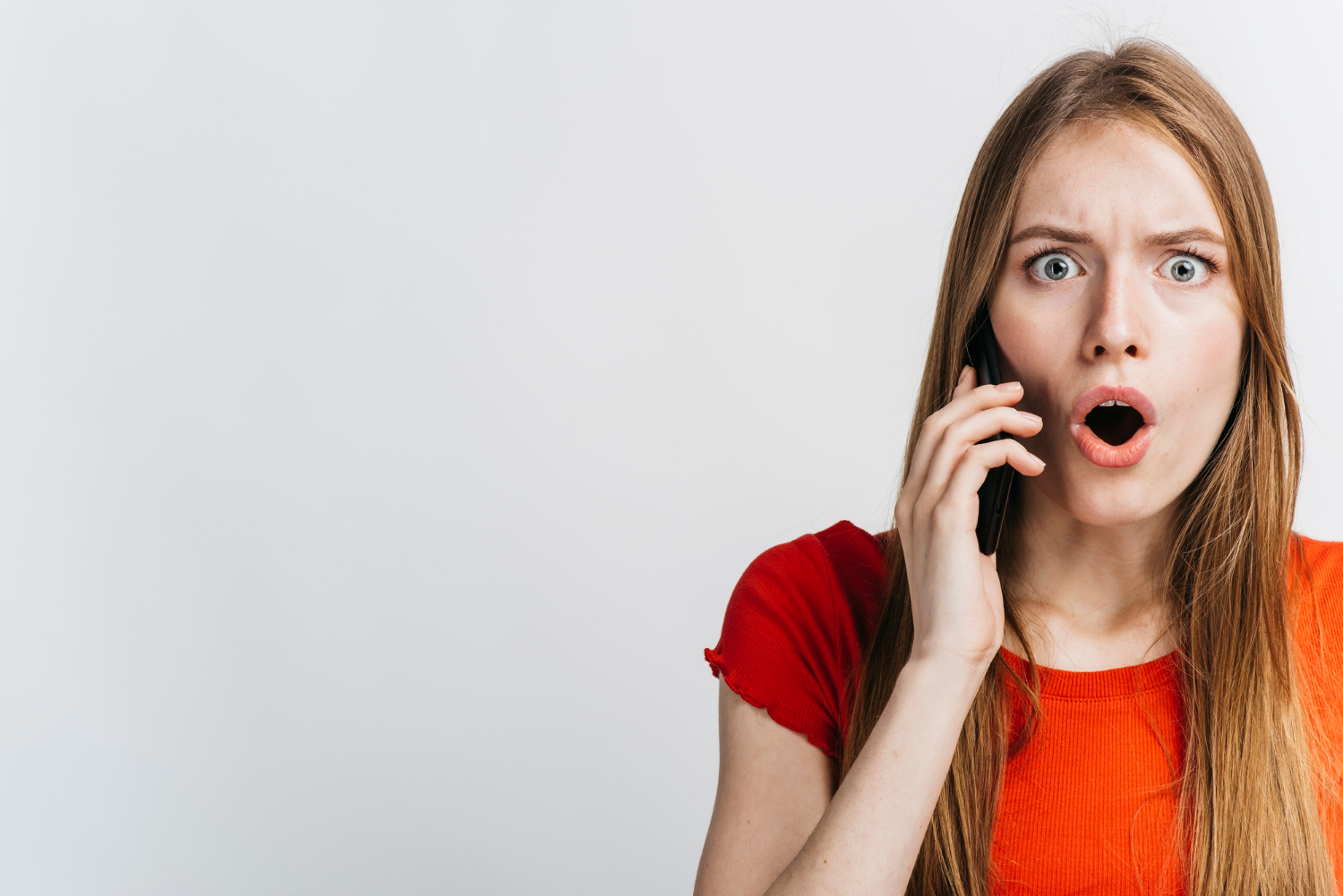 Une femme effrayée qui parle au téléphone | Source : Freepik