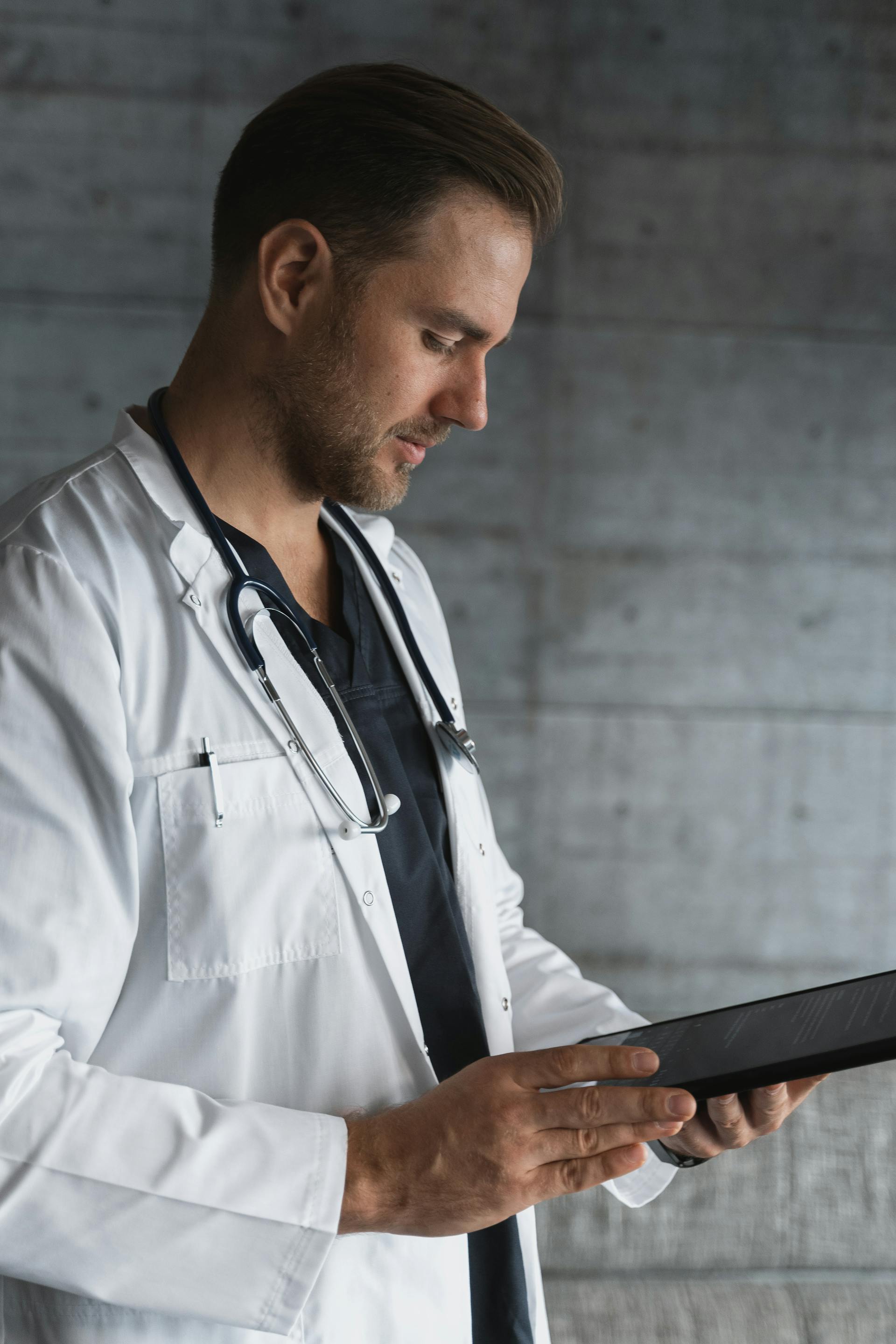 Un médecin de sexe masculin tenant une tablette informatique | Source : Pexels