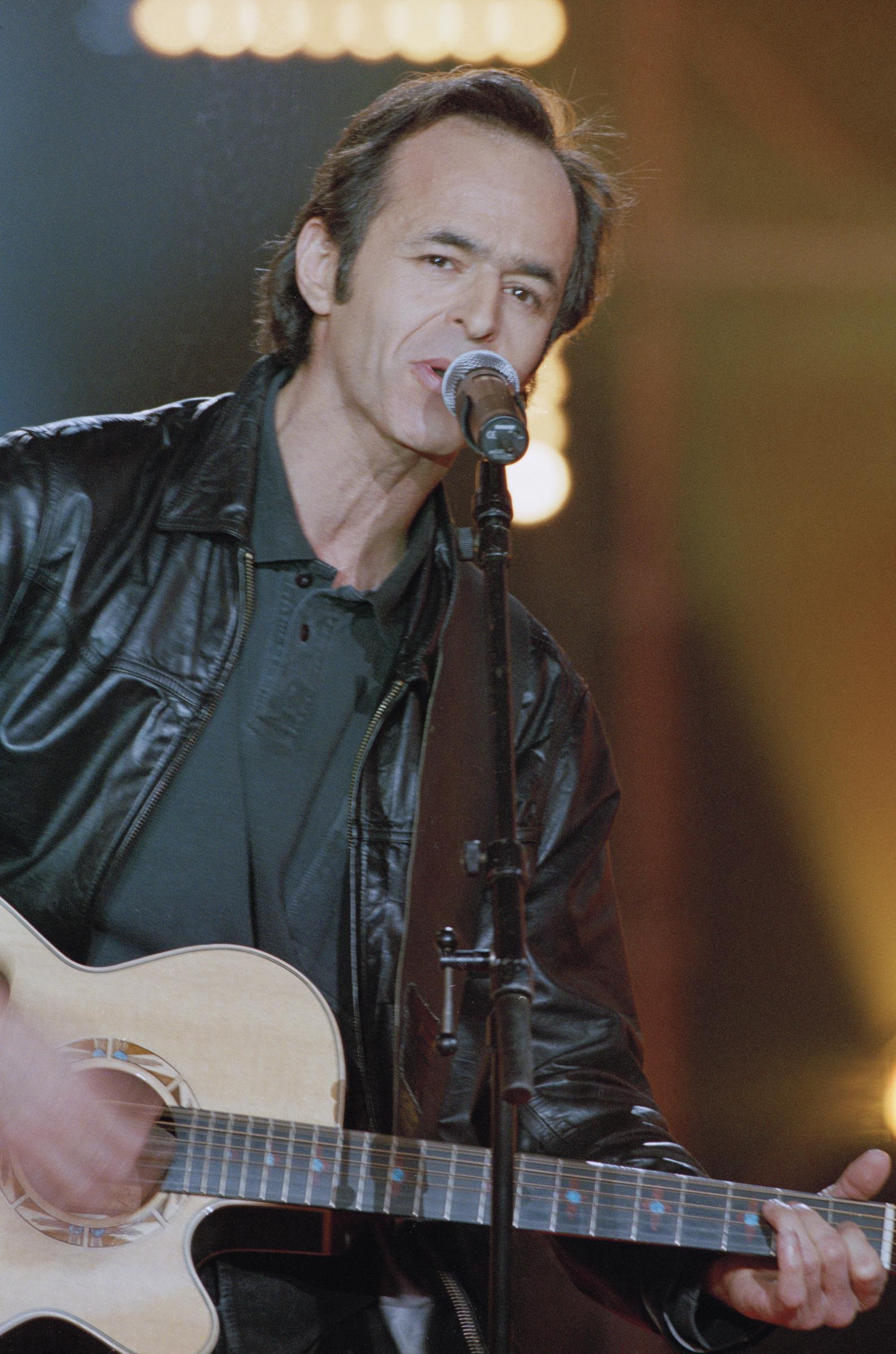 L'auteur-compositeur-interprète français Jean-Jacques Goldman jouant de la guitare dans l'émission Tapis Rouge présenté par Michel Drucker I Source : Getty Images