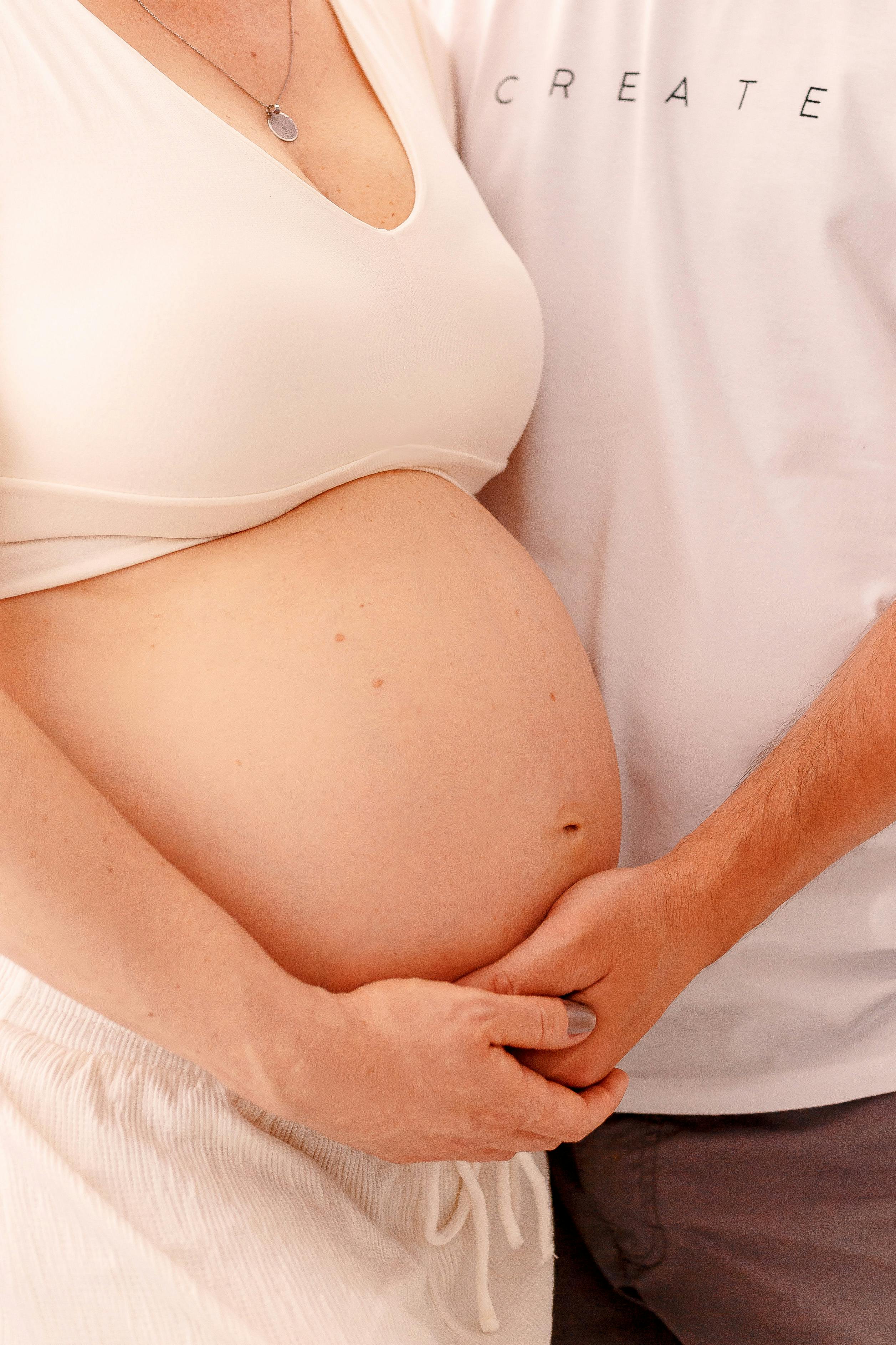Une femme plaçant la main d'un homme sur son ventre de femme enceinte | Source : Pexels