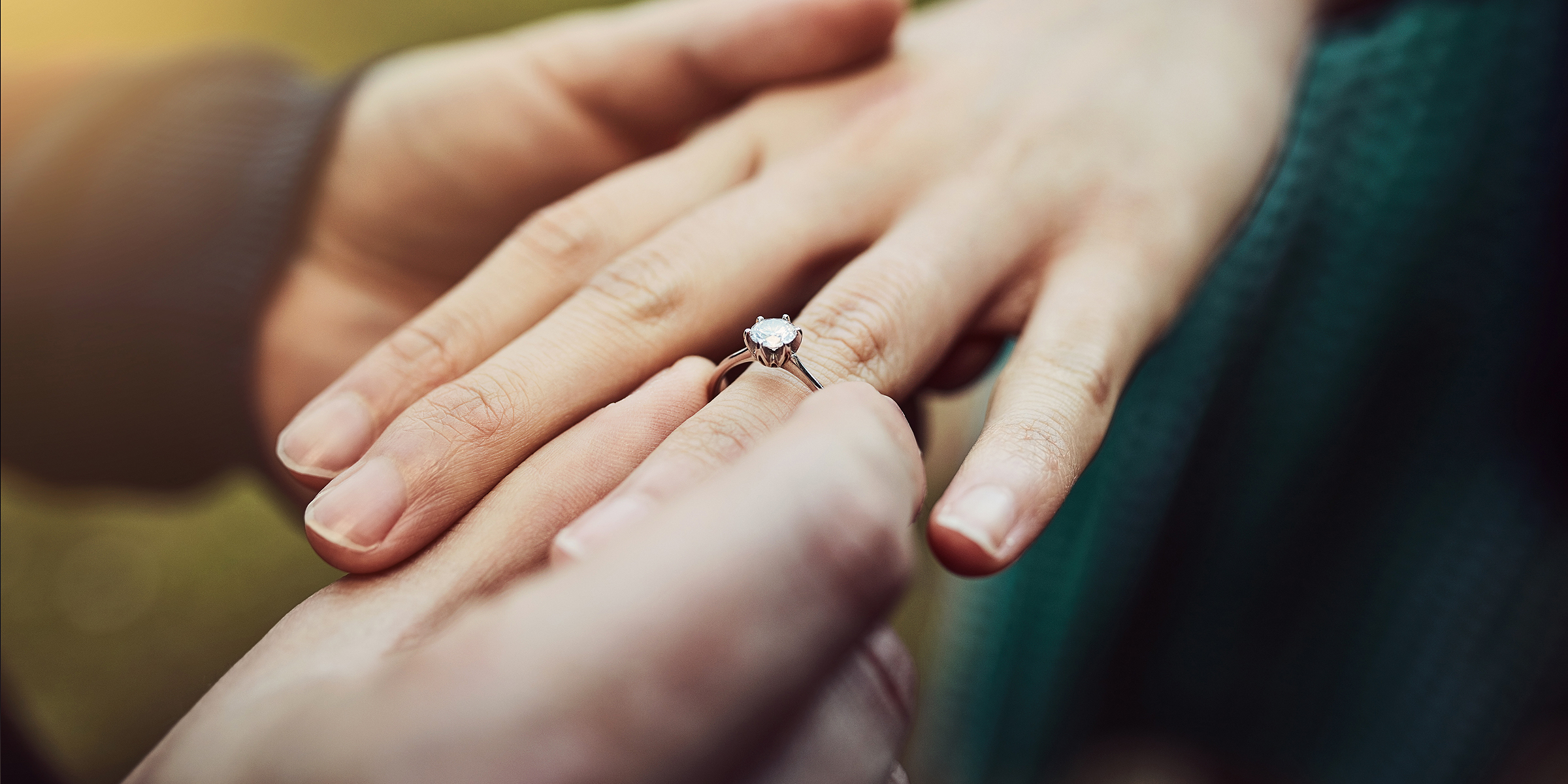 Un homme passant une bague de fiançailles à sa fiancée | Source : Getty Images