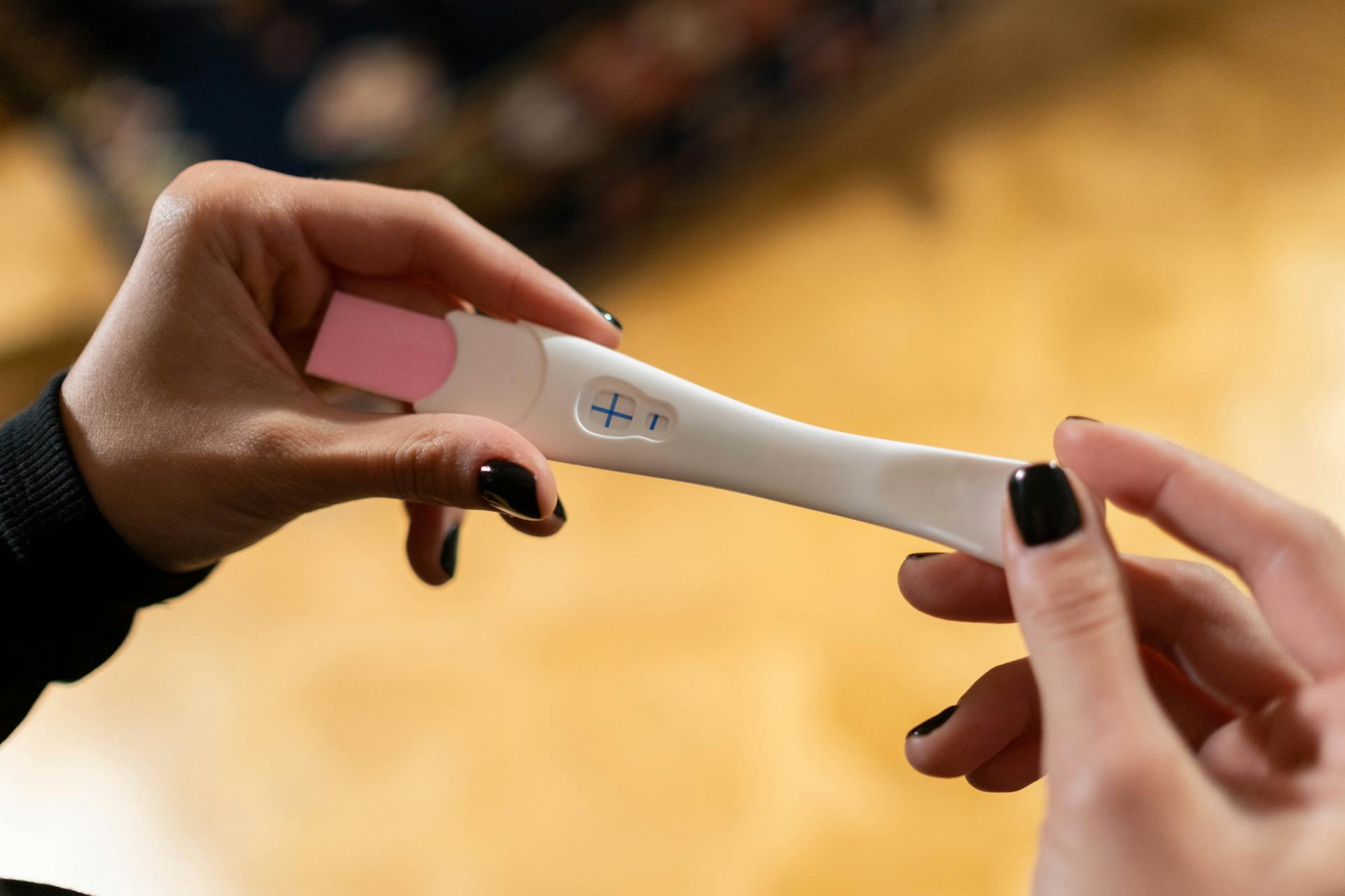 Une femme tenant un test de grossesse positif | Source : Pexels