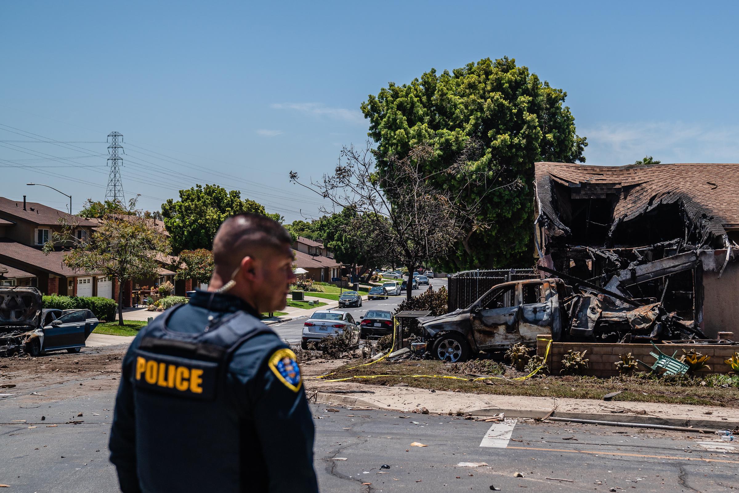 Un policier arpente les lieux après qu'un petit avion se soit écrasé sur une maison de San Diego, causant d'importants dégâts par le feu, le 22 mai 2025 | Source : Getty Images