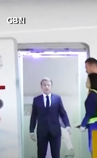 Emmanuel Macron avec deux membres de l'équipage se tenant sur le côté après que Brigitte ait poussé son visage. | Source : YouTube/GBNews