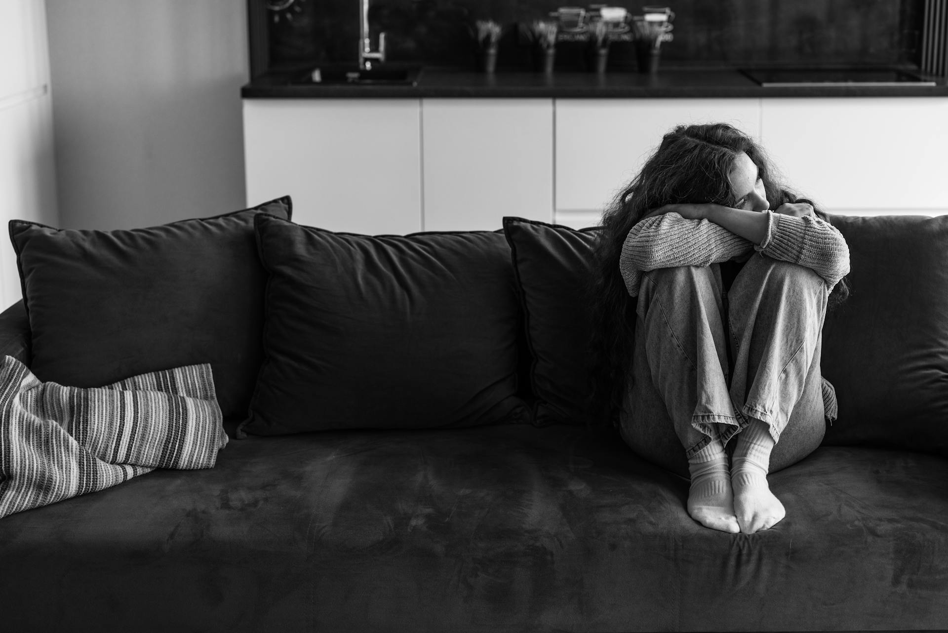 Une femme triste assise sur le canapé | Source : Pexels