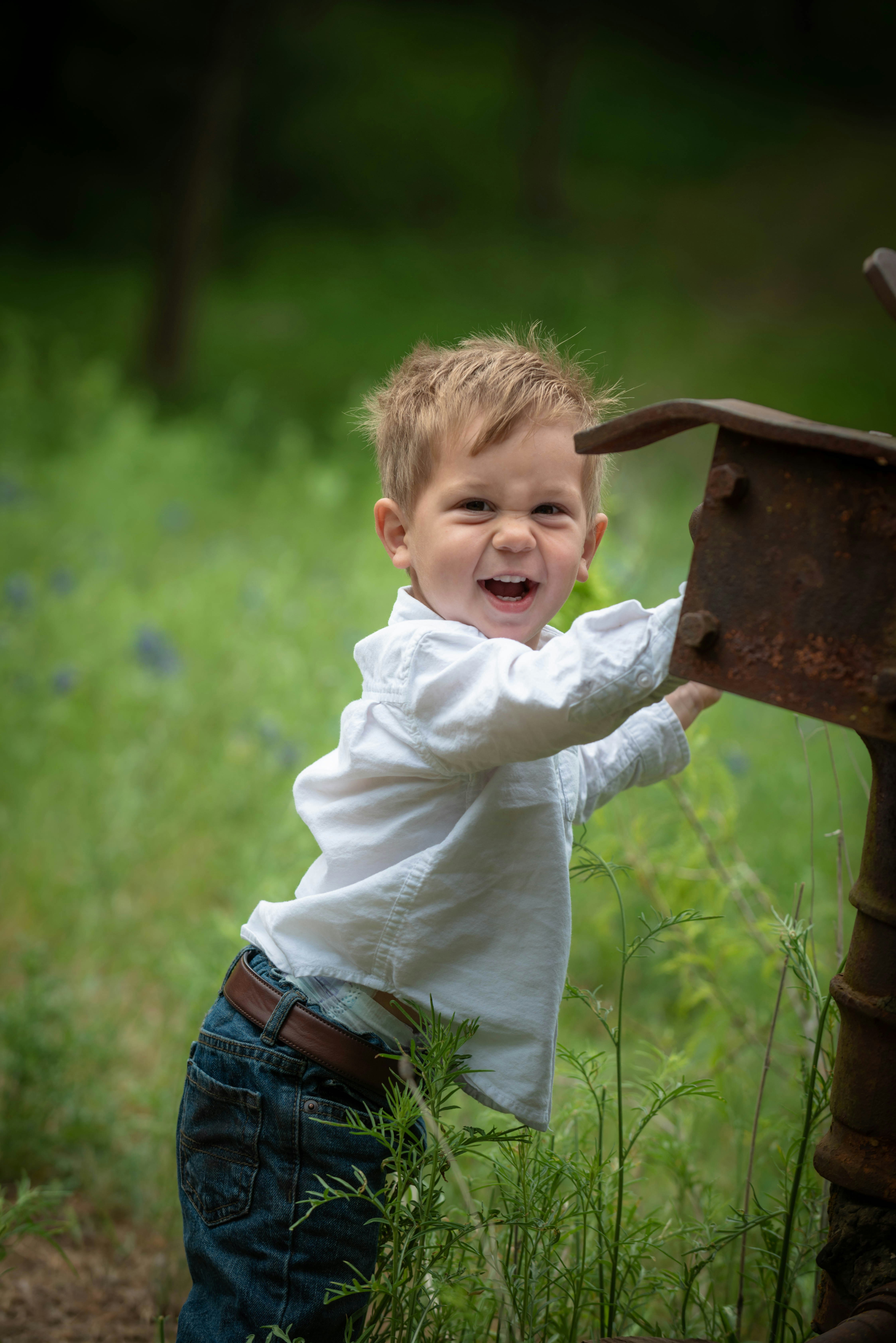Un petit garçon souriant se tenant à l'extérieur | Source : Unsplash