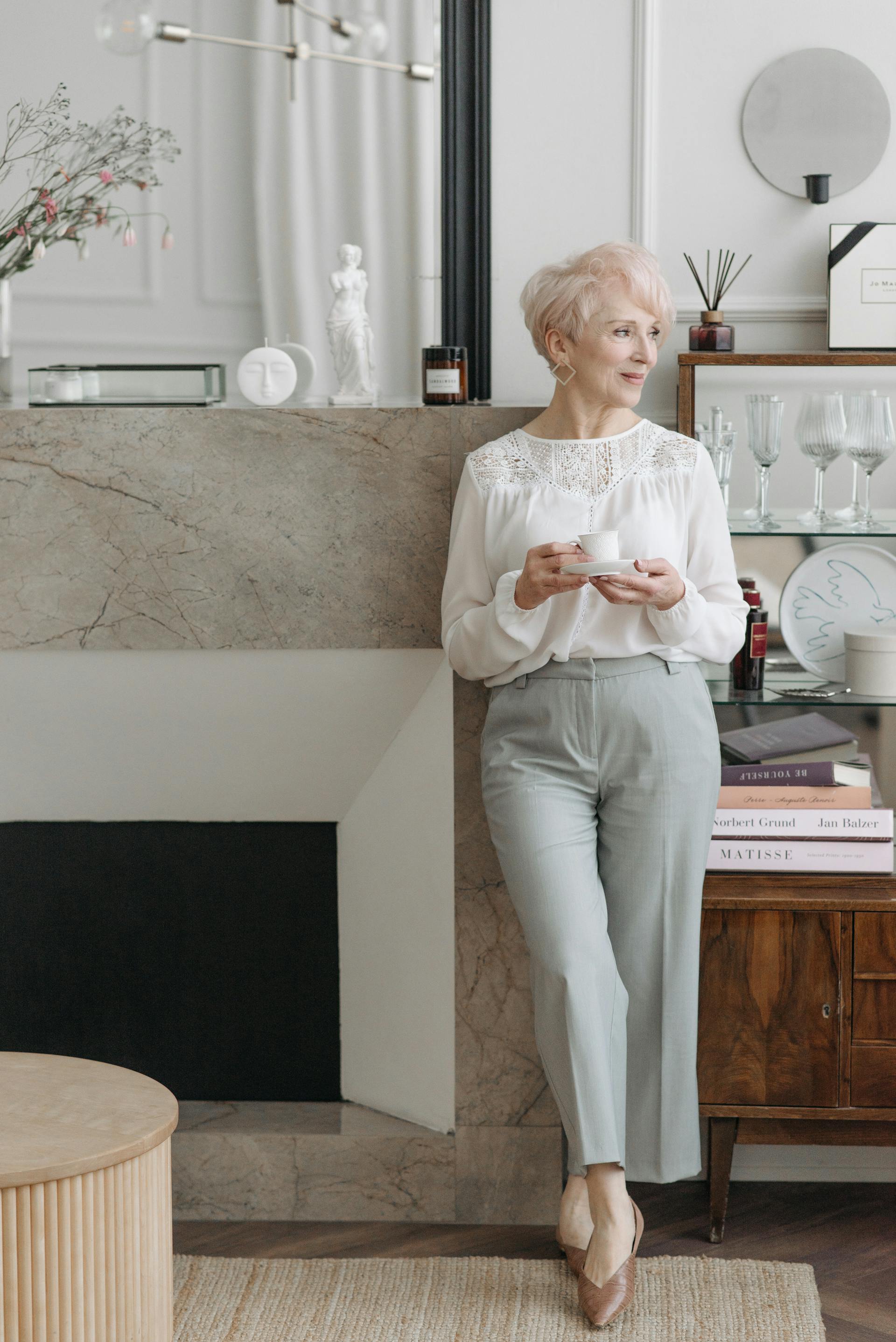 Une femme âgée debout à côté d'une cheminée | Source : Pexels