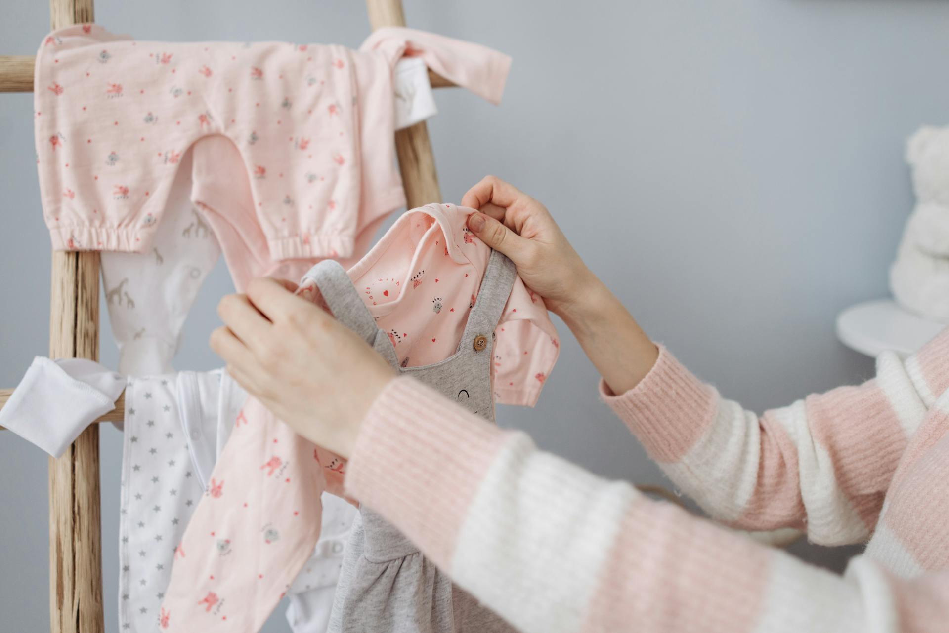 Une femme tenant des vêtements de bébé | Source : Pexels