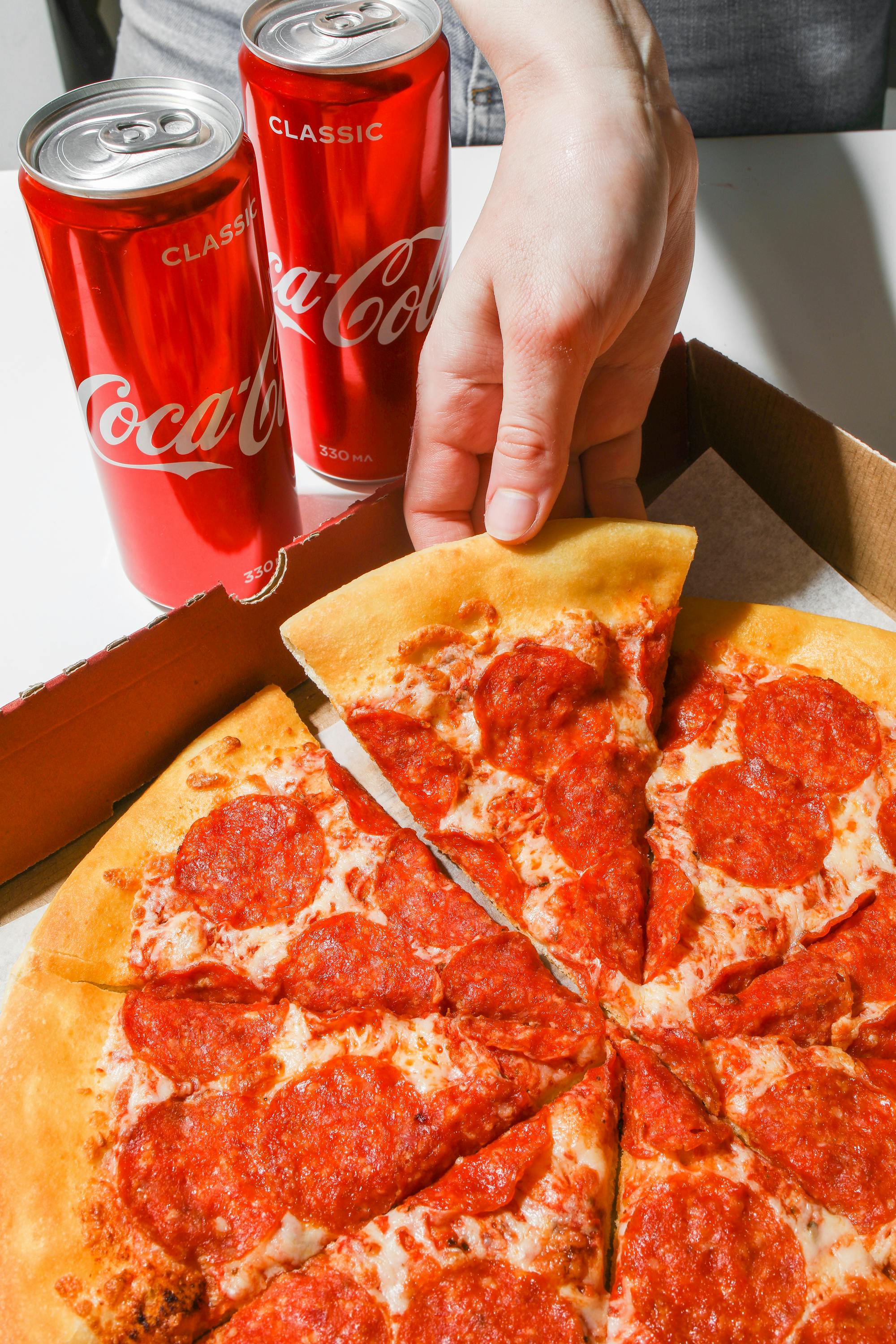 Une personne saisissant une part de pizza | Source : Pexels