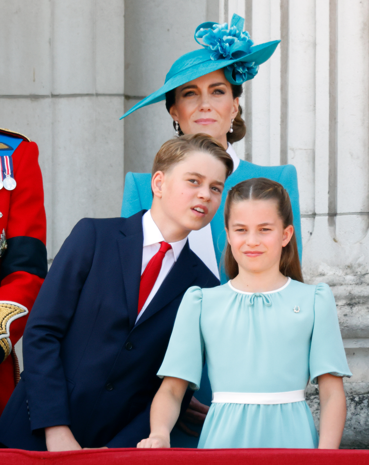 Le prince George regarde par-dessus l'épaule de la princesse Charlotte tout en observant le défilé aérien de la RAF depuis le balcon du palais de Buckingham lors du Trooping the Colour de 2025.