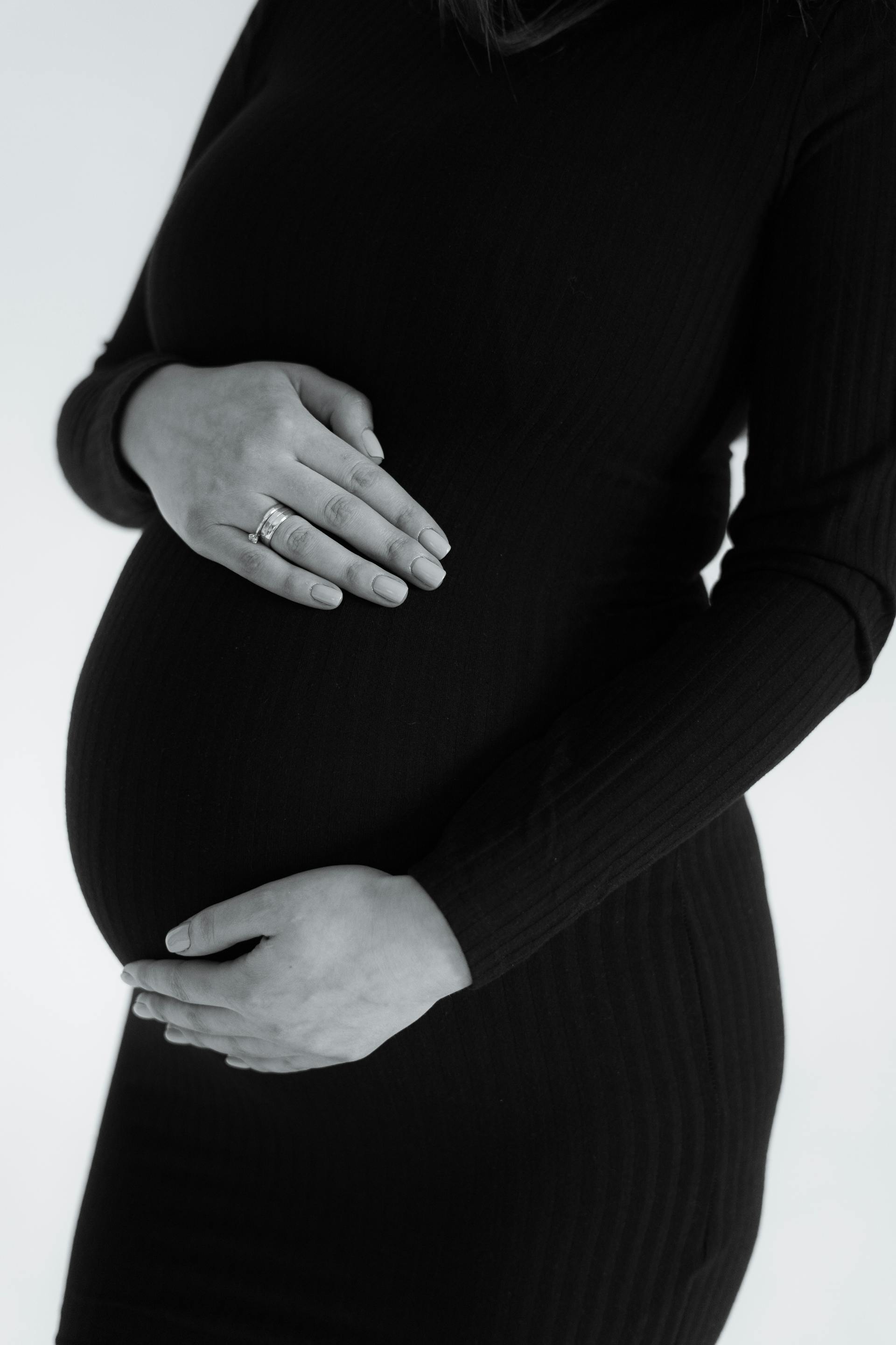 Photo en niveaux de gris d'une femme tenant son baby bump | Source : Pexels