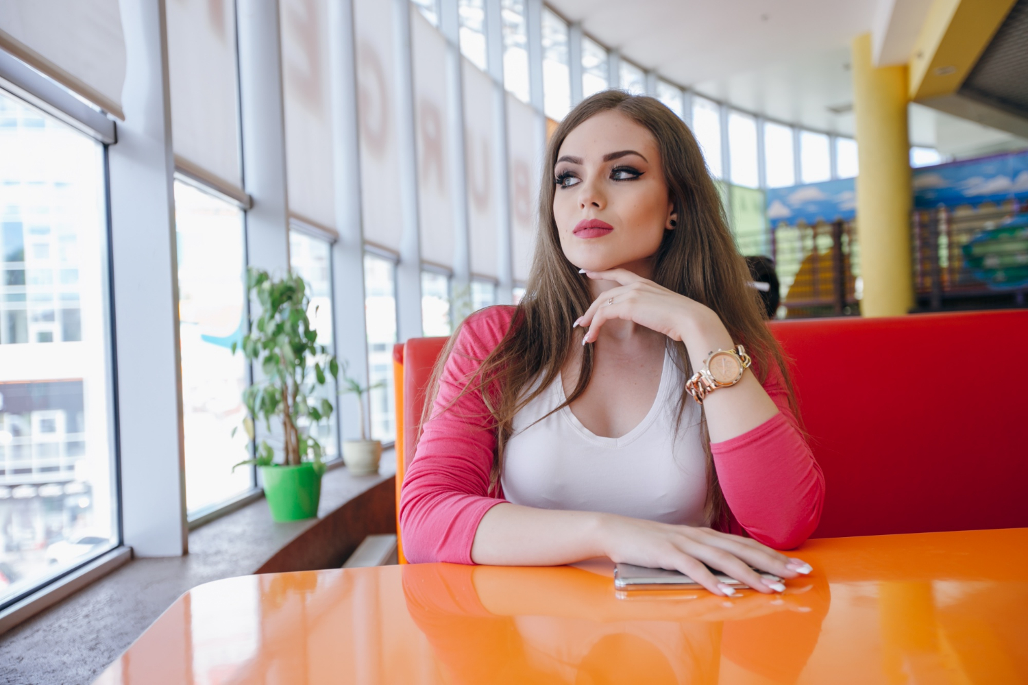 Une jeune femme assise dans un restaurant | Source : Freepik