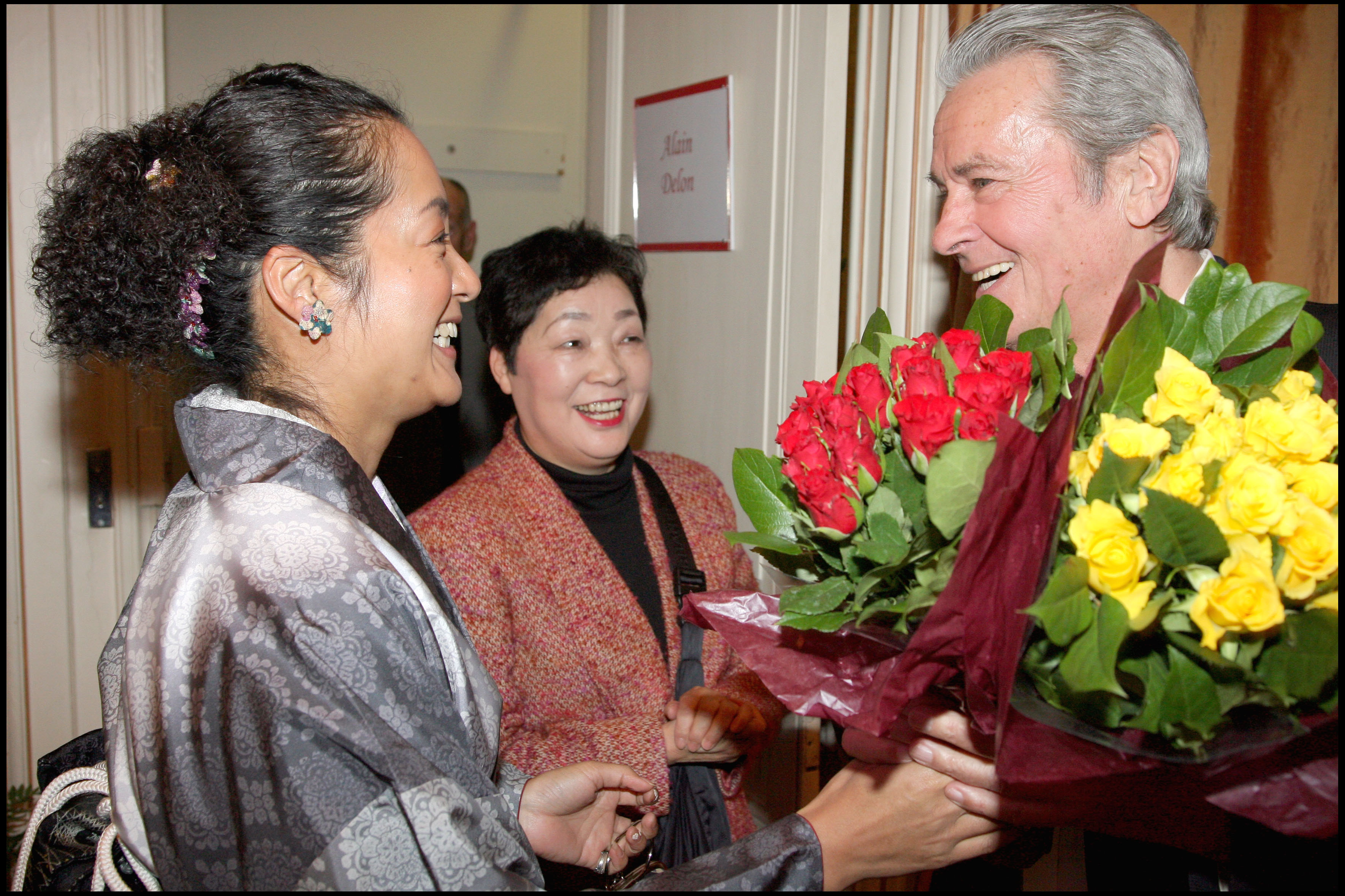 Alain Delon recevant des fleurs de fans venus du Japon pour le voir dans la pièce « Love Letters » à Paris, en France, en 2008. | Source : Getty Images