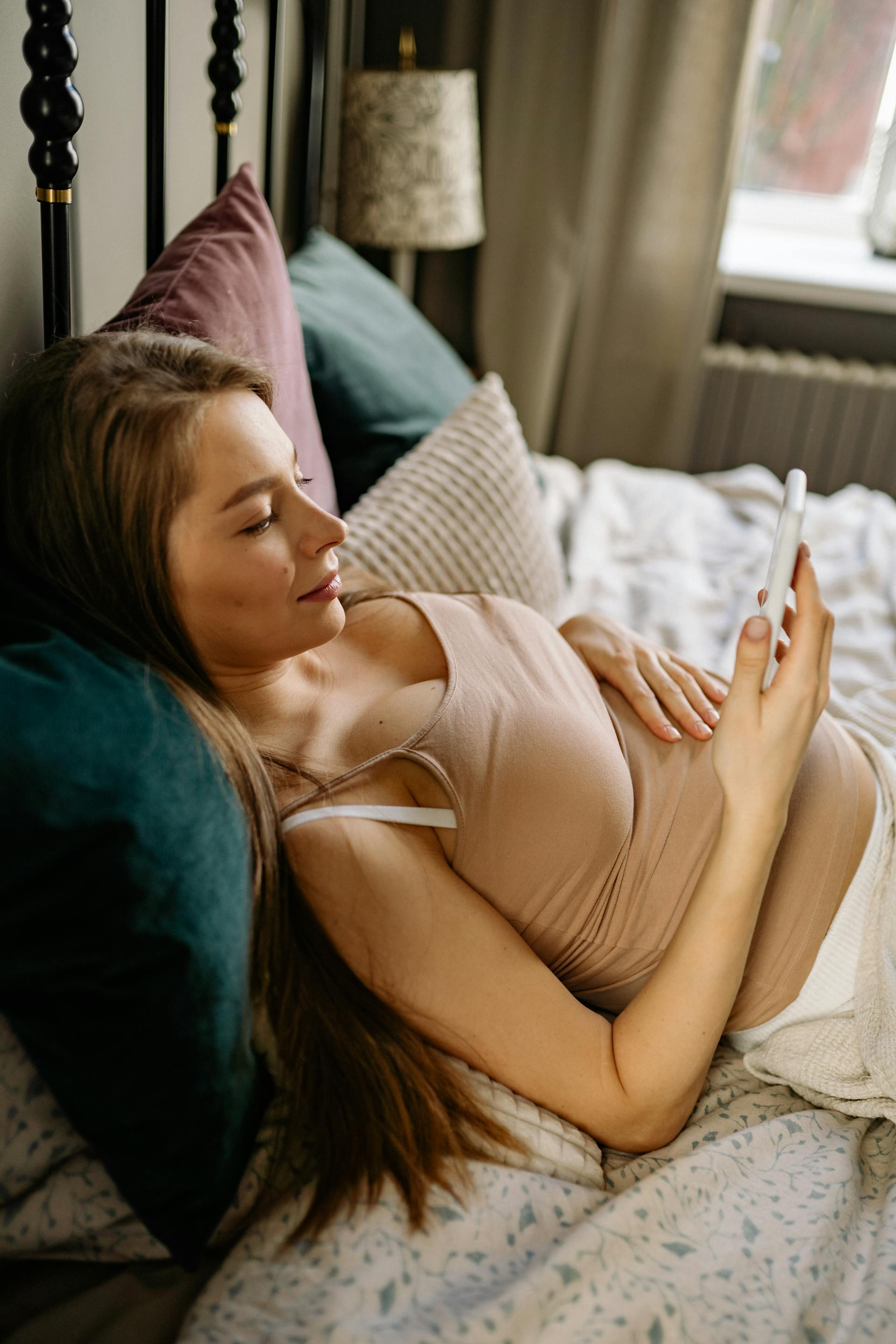 Une jeune femme se détend sur un lit | Source : Pexels