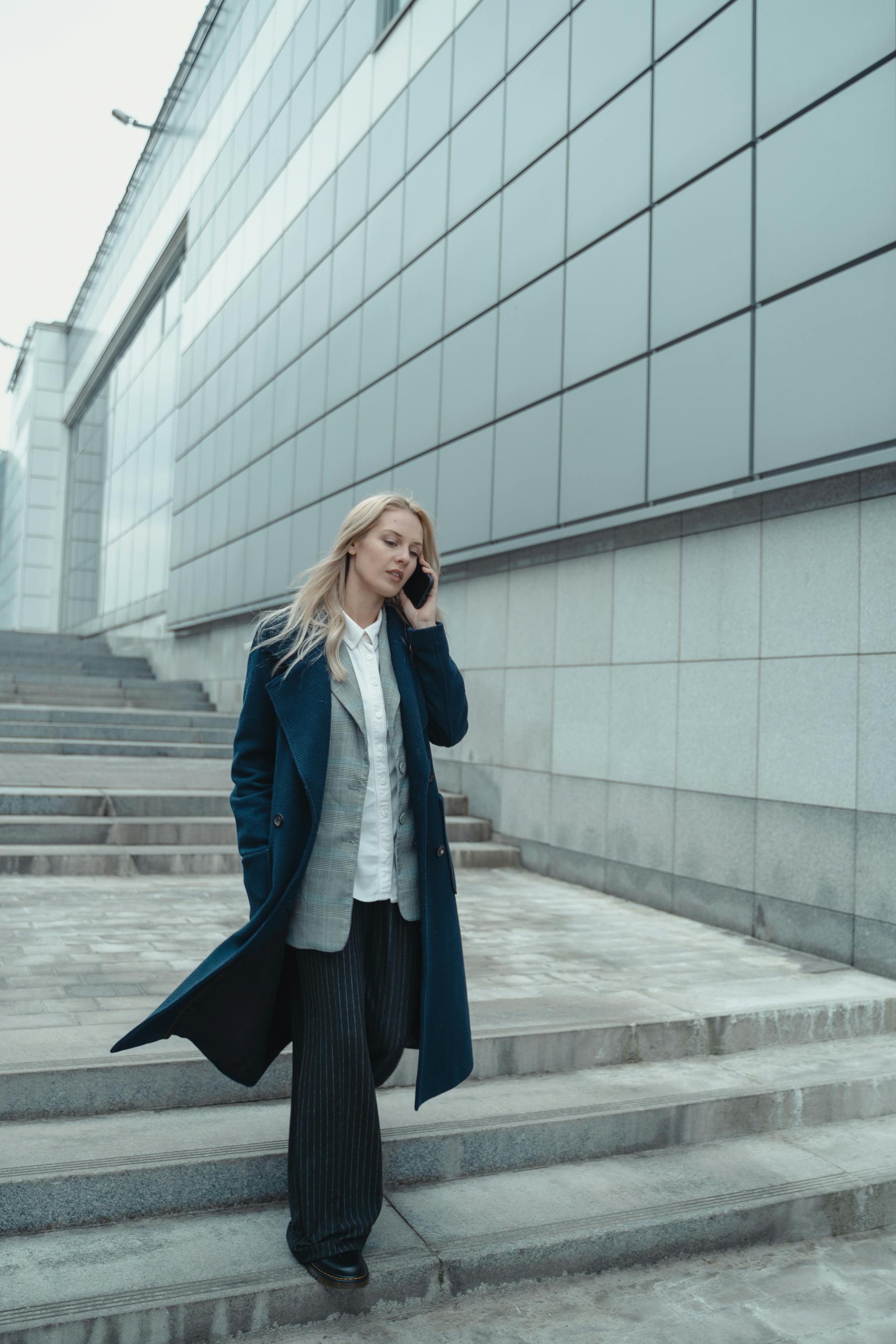 Une femme qui parle au téléphone tout en descendant un escalier | Source : Pexels