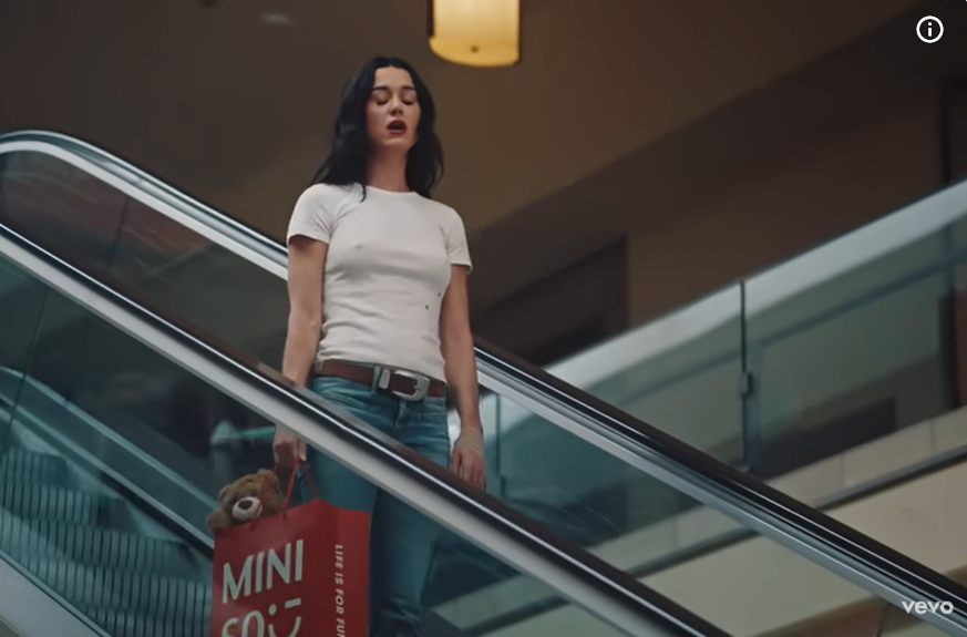 Katy Perry se tient debout sur un escalator en mouvement, comme on peut le voir dans son clip vidéo « Bandaids », daté du 7 novembre 2025. | Source : Youtube/KatyPerry