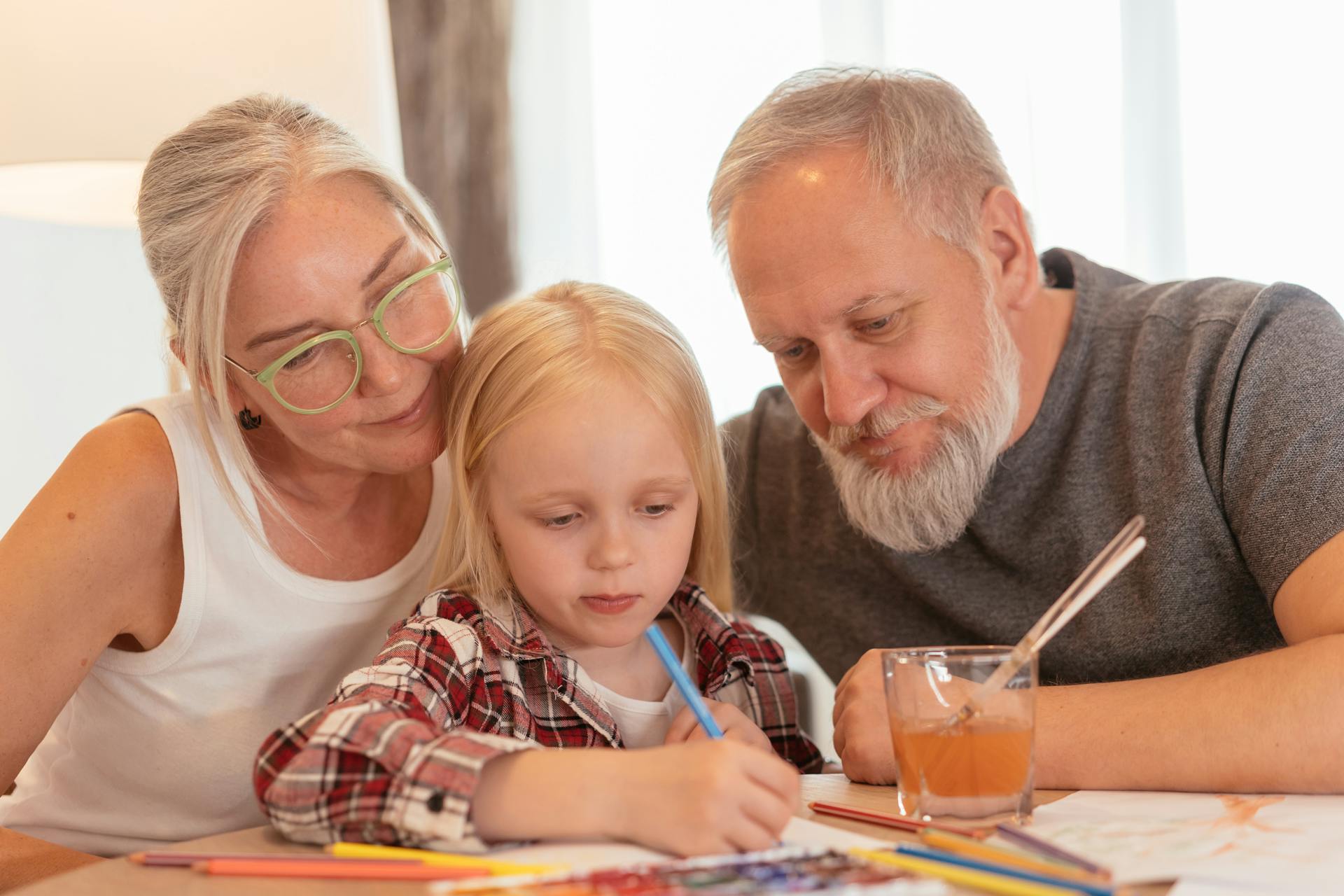 Une petite fille qui fait du coloriage avec ses grands-parents | Source : Pexels