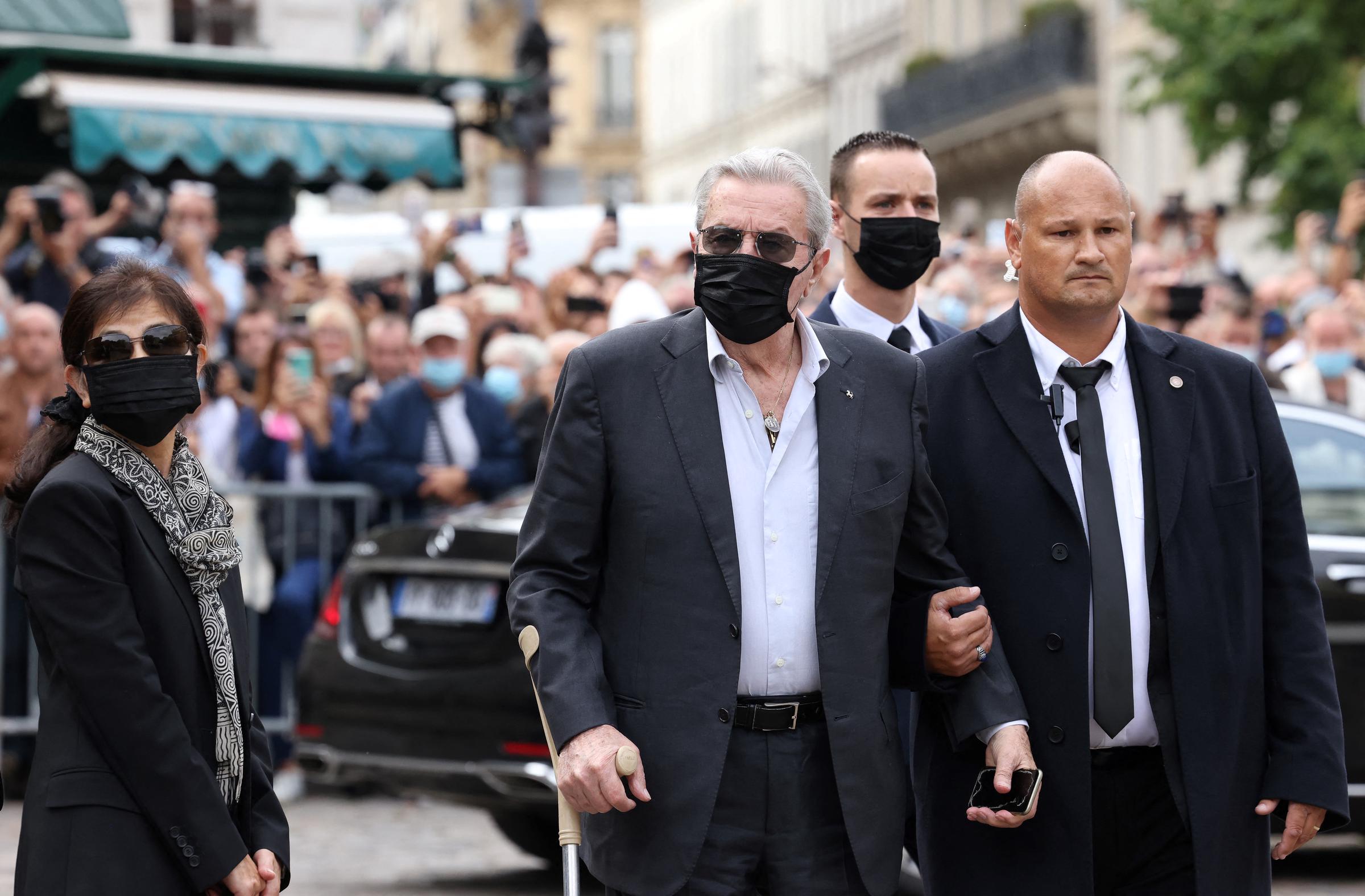 L'acteur français Alain Delon (au centre) et sa compagne et assistante Hiromi Rollin (à gauche) arrivent à la cérémonie funéraire de l'acteur français Jean-Paul Belmondo à l'église Saint-Germain-des-Prés à Paris, le 10 septembre 2021 I Source : Getty Images