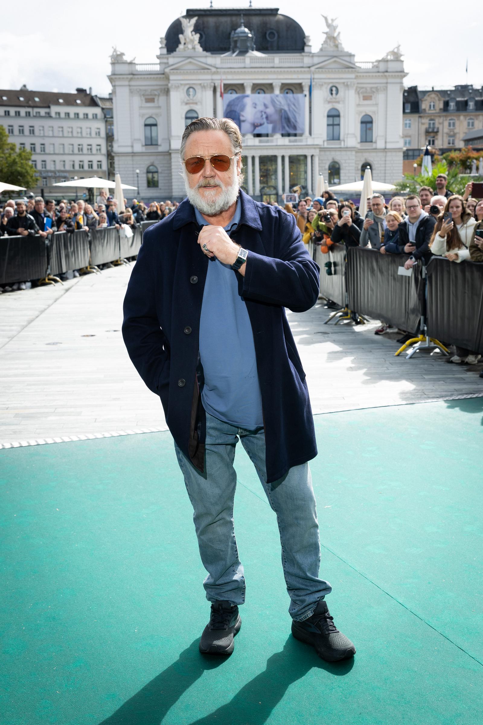 Russell Crowe pose sur le tapis vert pour « Nuremberg » lors du 21e Festival du film de Zurich, le 27 septembre 2025, en Suisse. Vêtu d'un manteau bleu marine, d'une chemise bleue et d'un jean clair, il semble nettement plus mince, révélant les résultats de sa perte de poids de 25 kg, alors qu'il salue ses fans avec une posture confiante et une silhouette affinée.