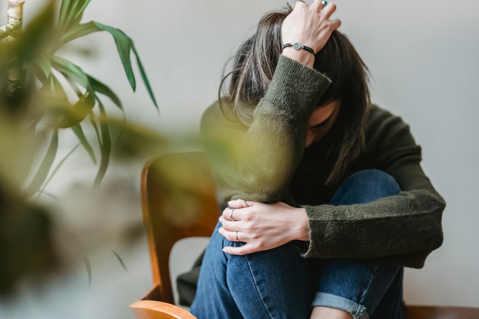 Une femme assise, la tête dans une main | Source : Pexels