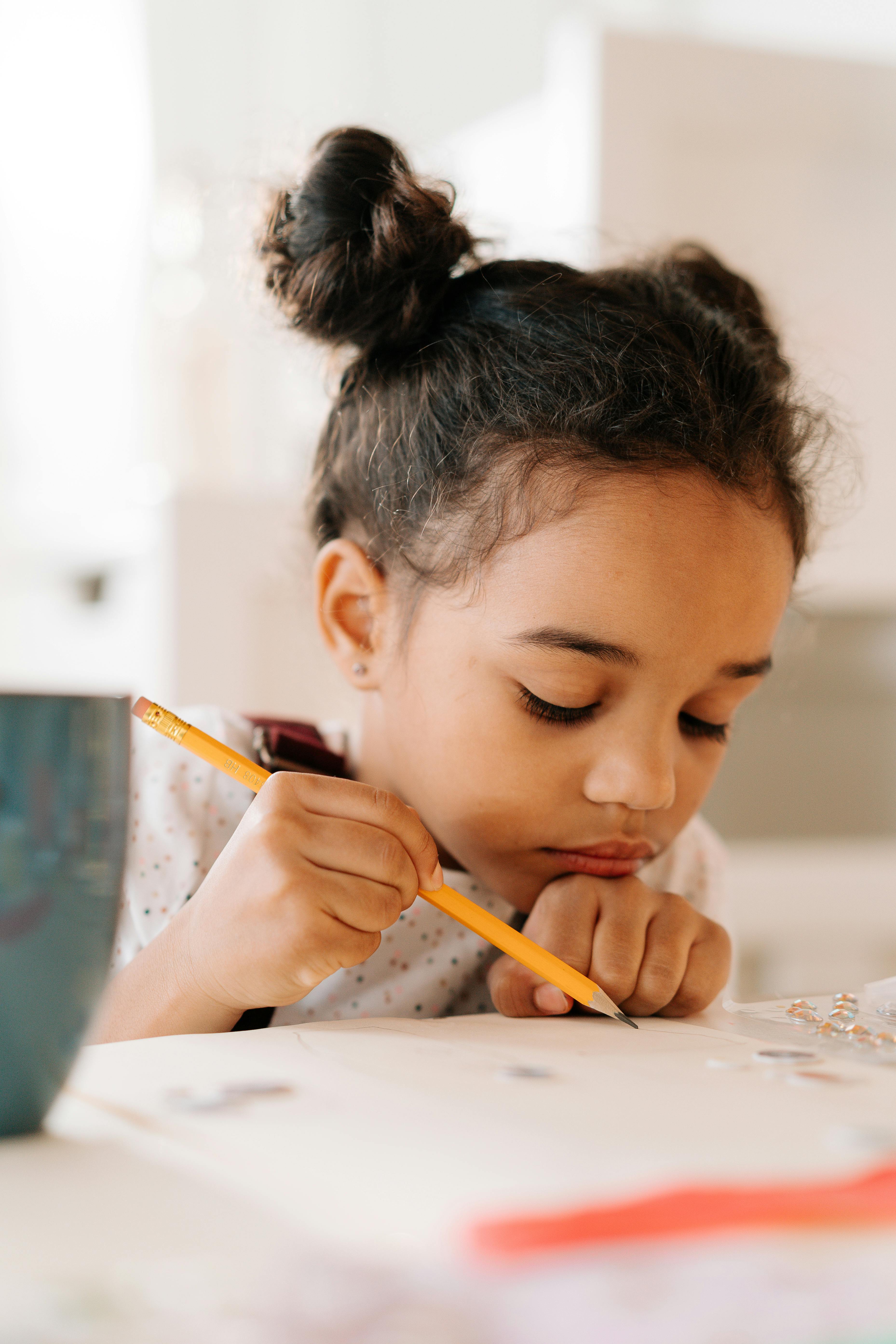 Fille tenant un crayon | Source : Pexels