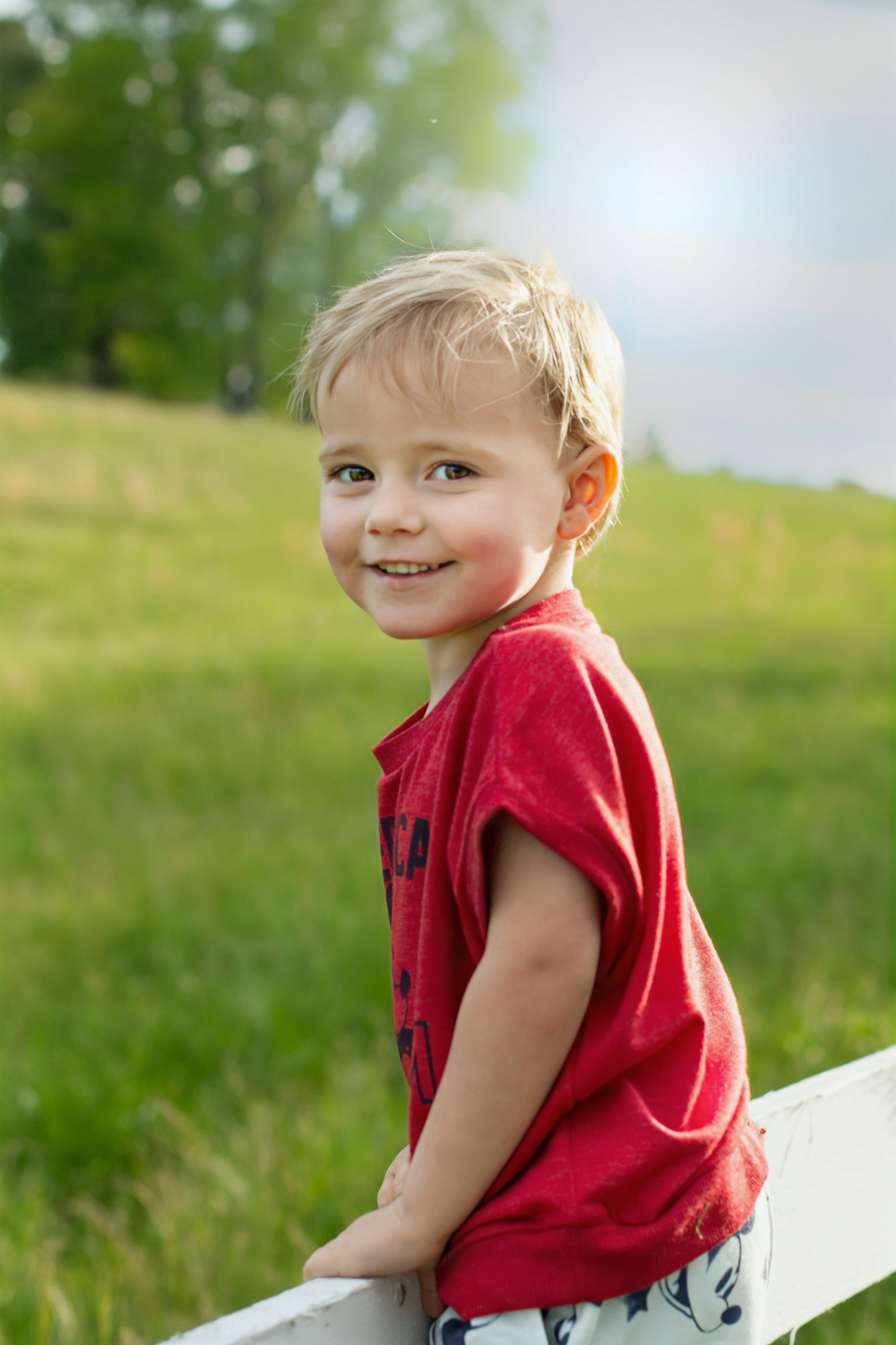 Un petit garçon heureux se tenant à l'extérieur | Source : Unsplash