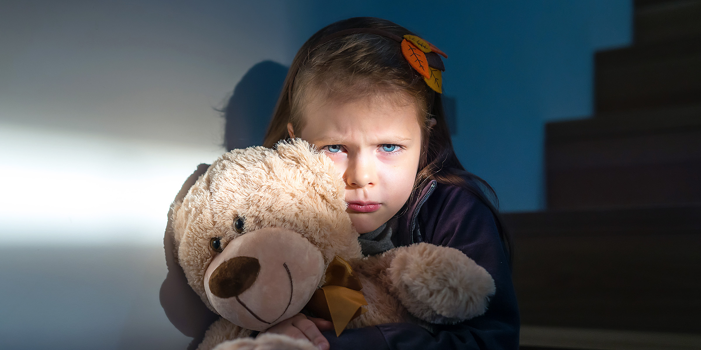 Une petite fille triste et effrayée serrant un ours en peluche | Source : Shutterstock