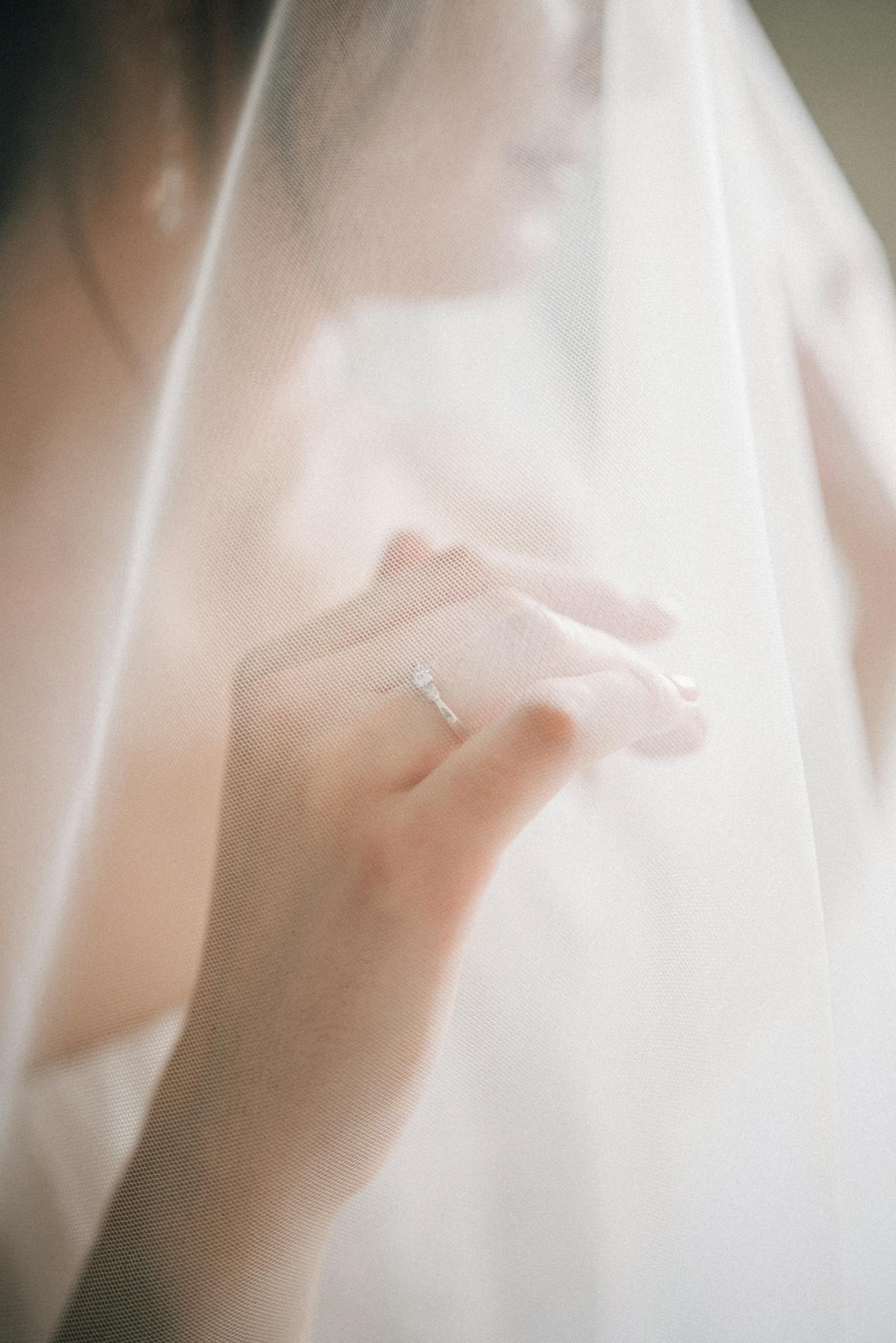 Une mariée perdue dans ses pensées tout en donnant un aperçu de sa bague en diamant argenté | Source : Pexels