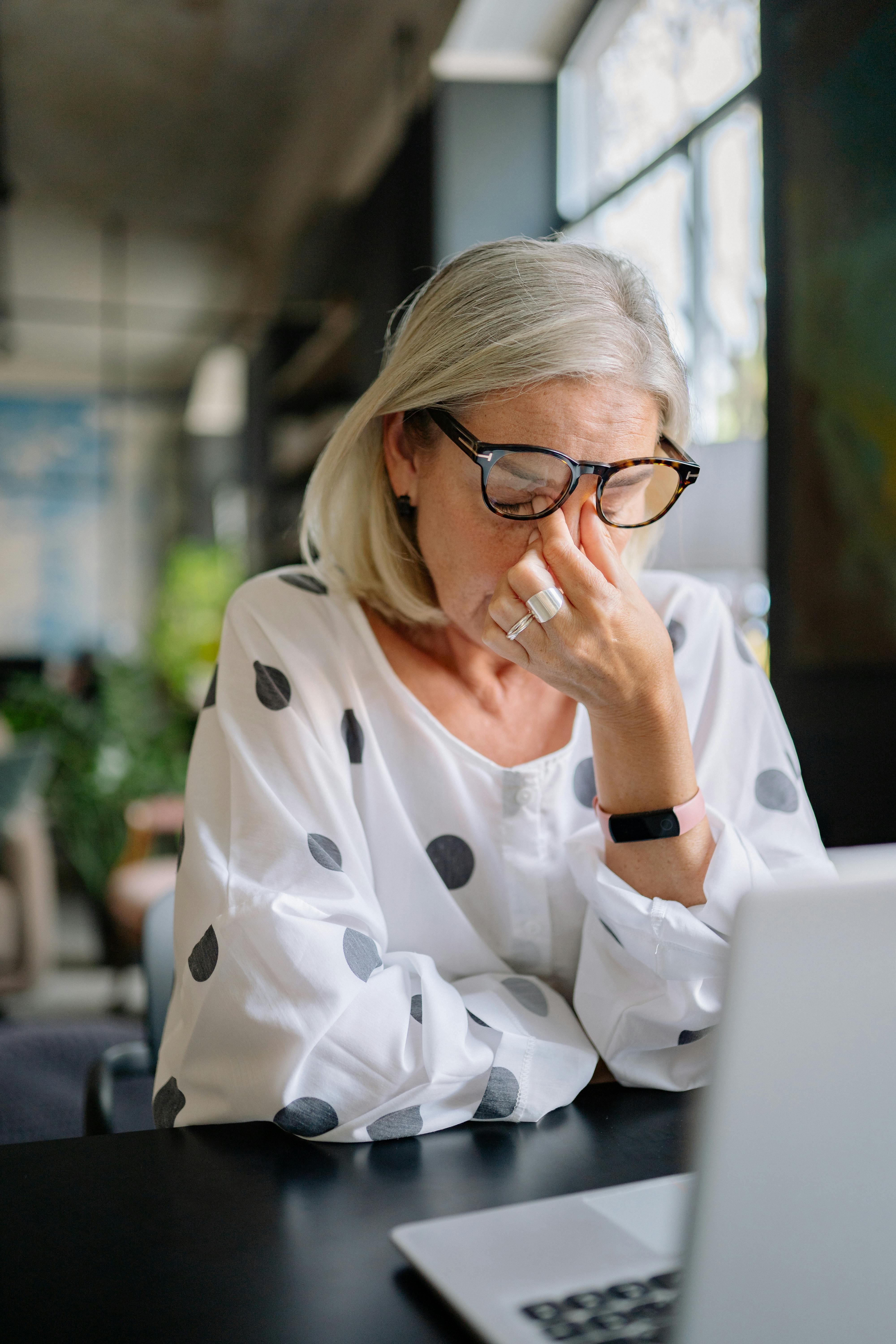 Une femme âgée se tenant l'arête de son nez | Source : Pexels
