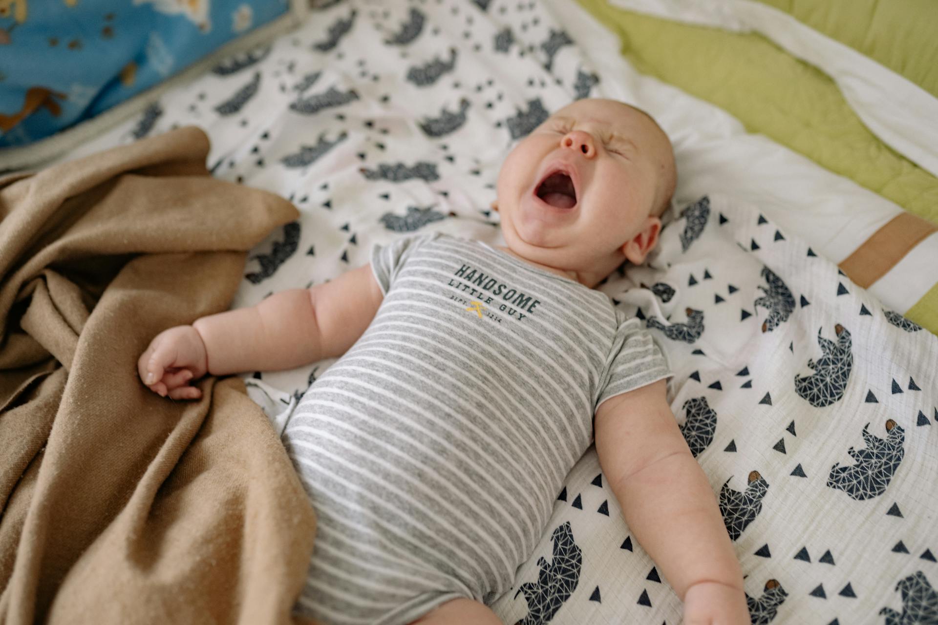 Un bébé en pleurs allongé sur un lit | Source : Pexels