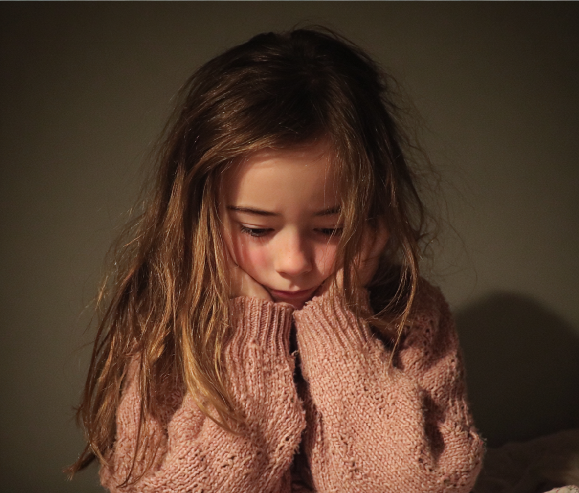 Une petite fille qui se tient la tête | Source : Midjourney