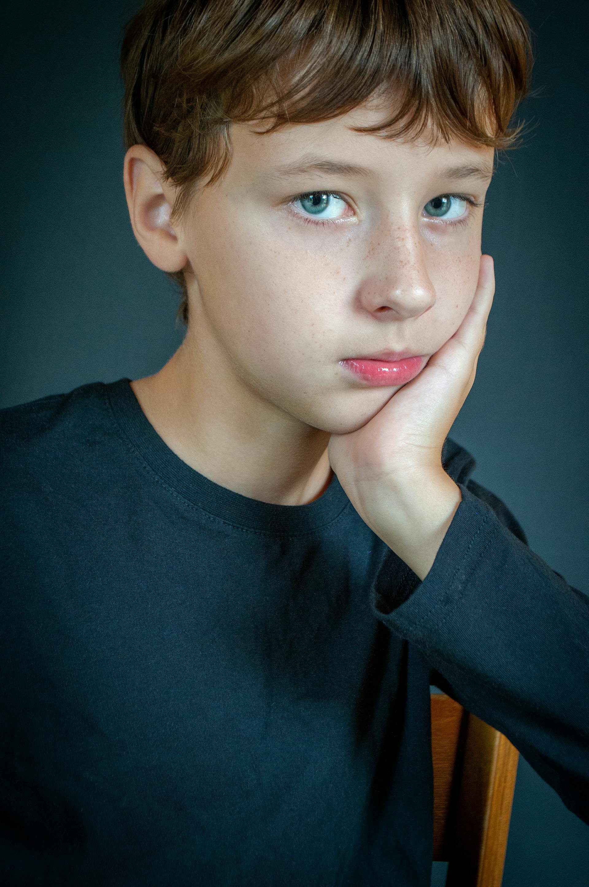 Un adolescent avec une main posée sur sa joue | Source : Pexels