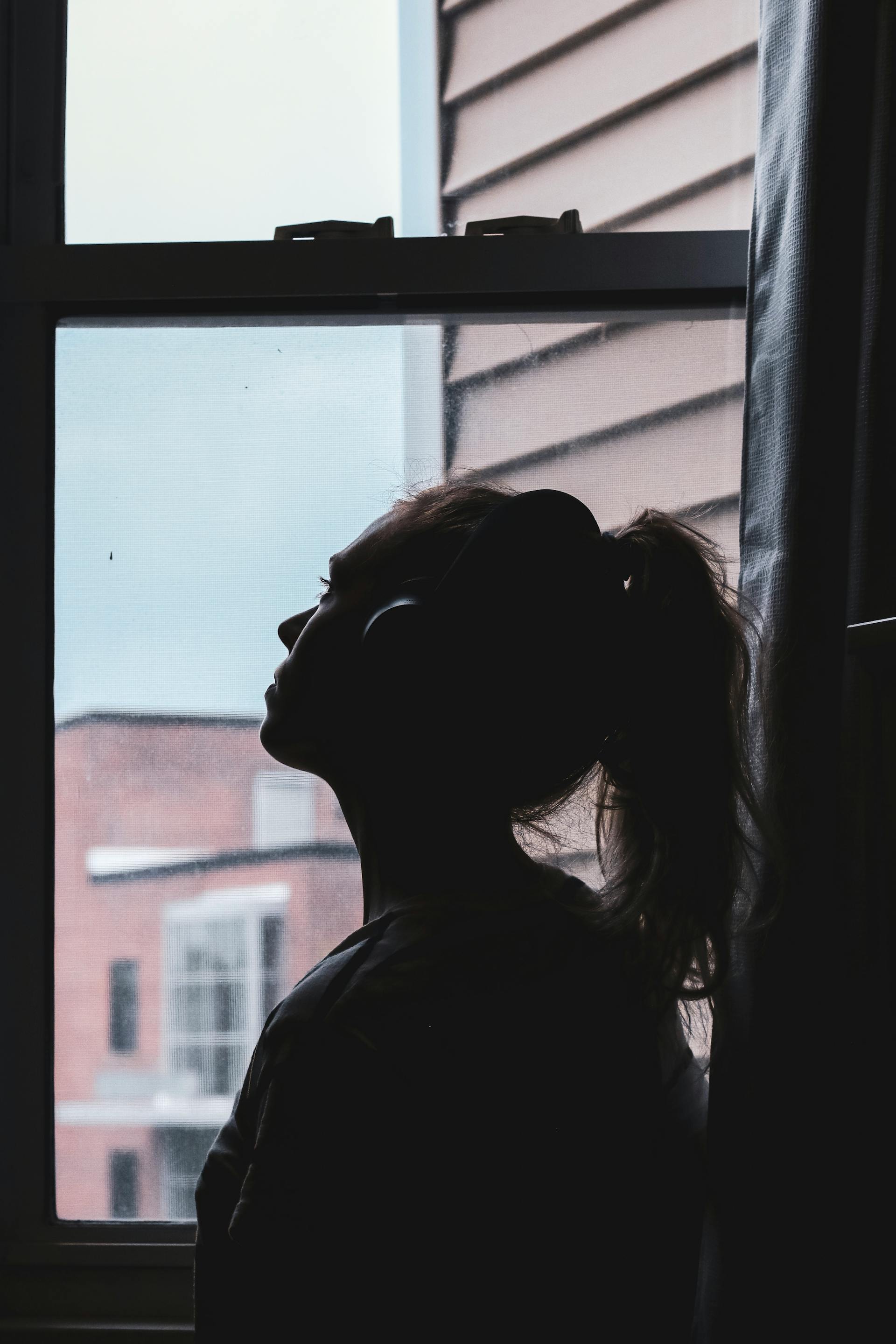 Une jeune femme qui regarde par la fenêtre | Source : Pexels