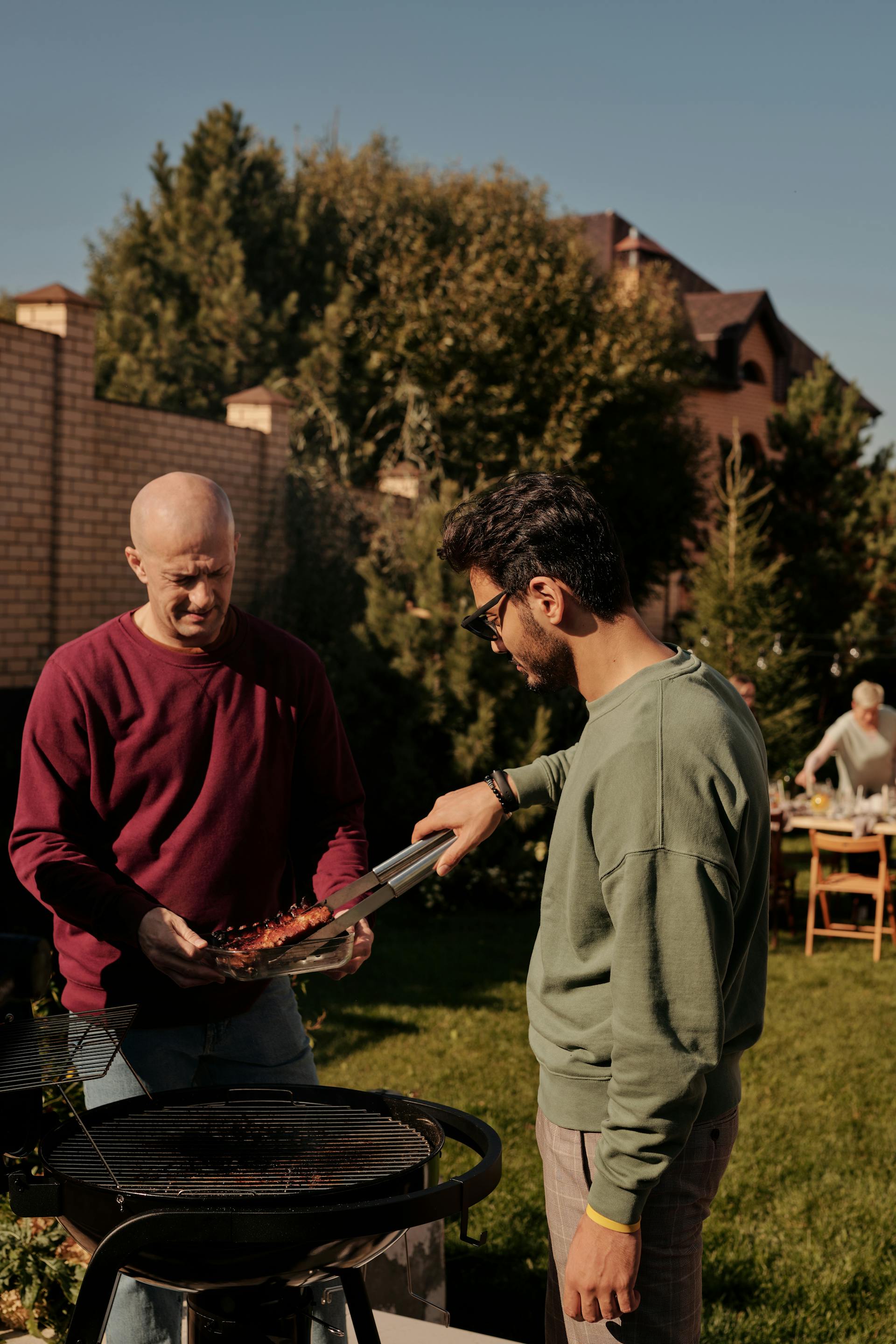 Deux hommes font un barbecue dans l'arrière-cour | Source : Pexels