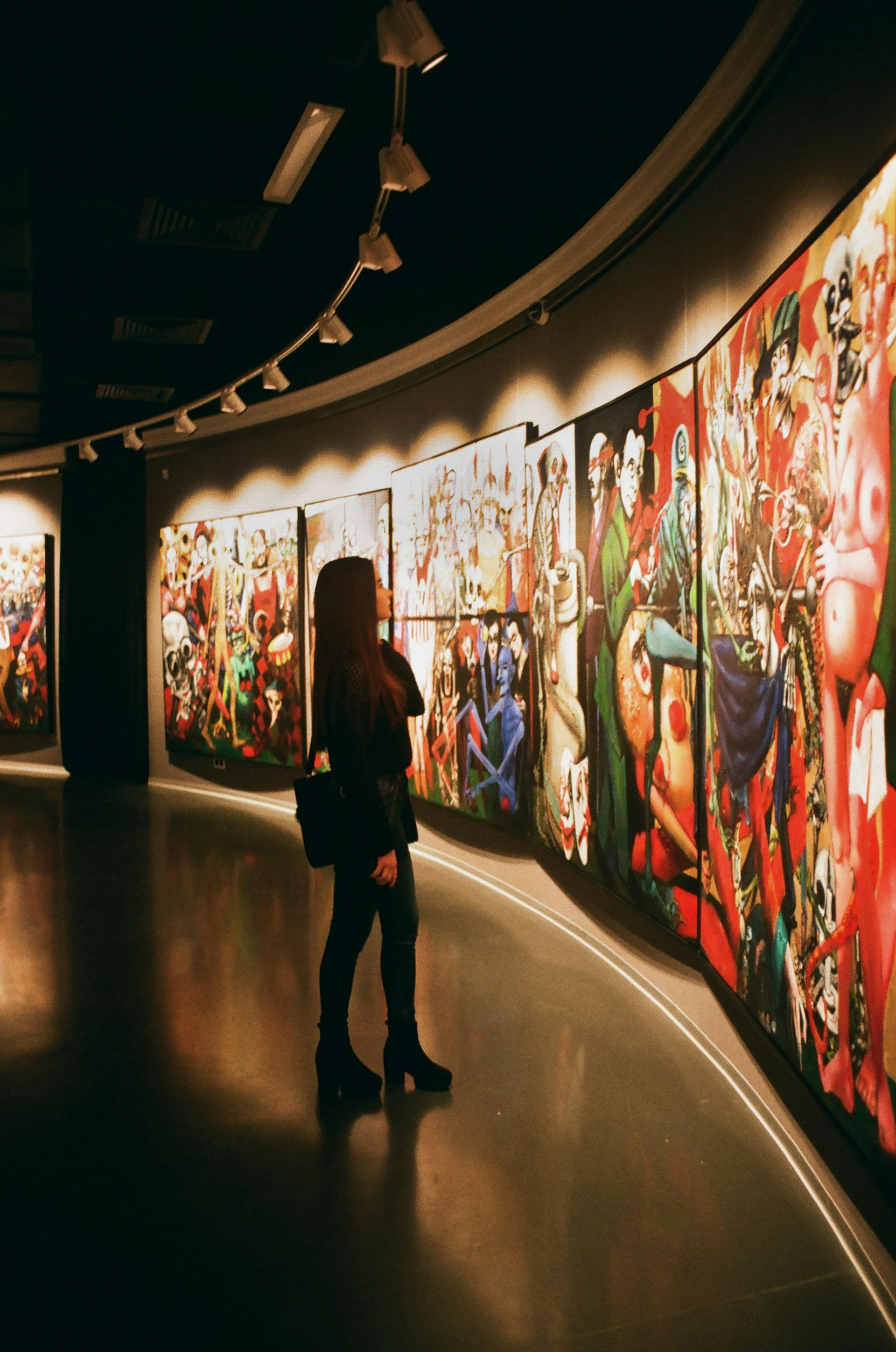 Une femme regarde des tableaux dans une galerie d'art | Source : Pexels