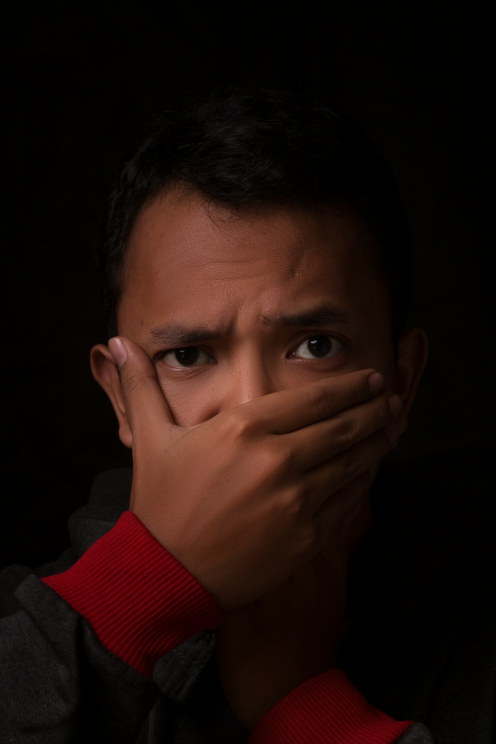 Un homme se couvrant la bouche d'une main | Source : Unsplash