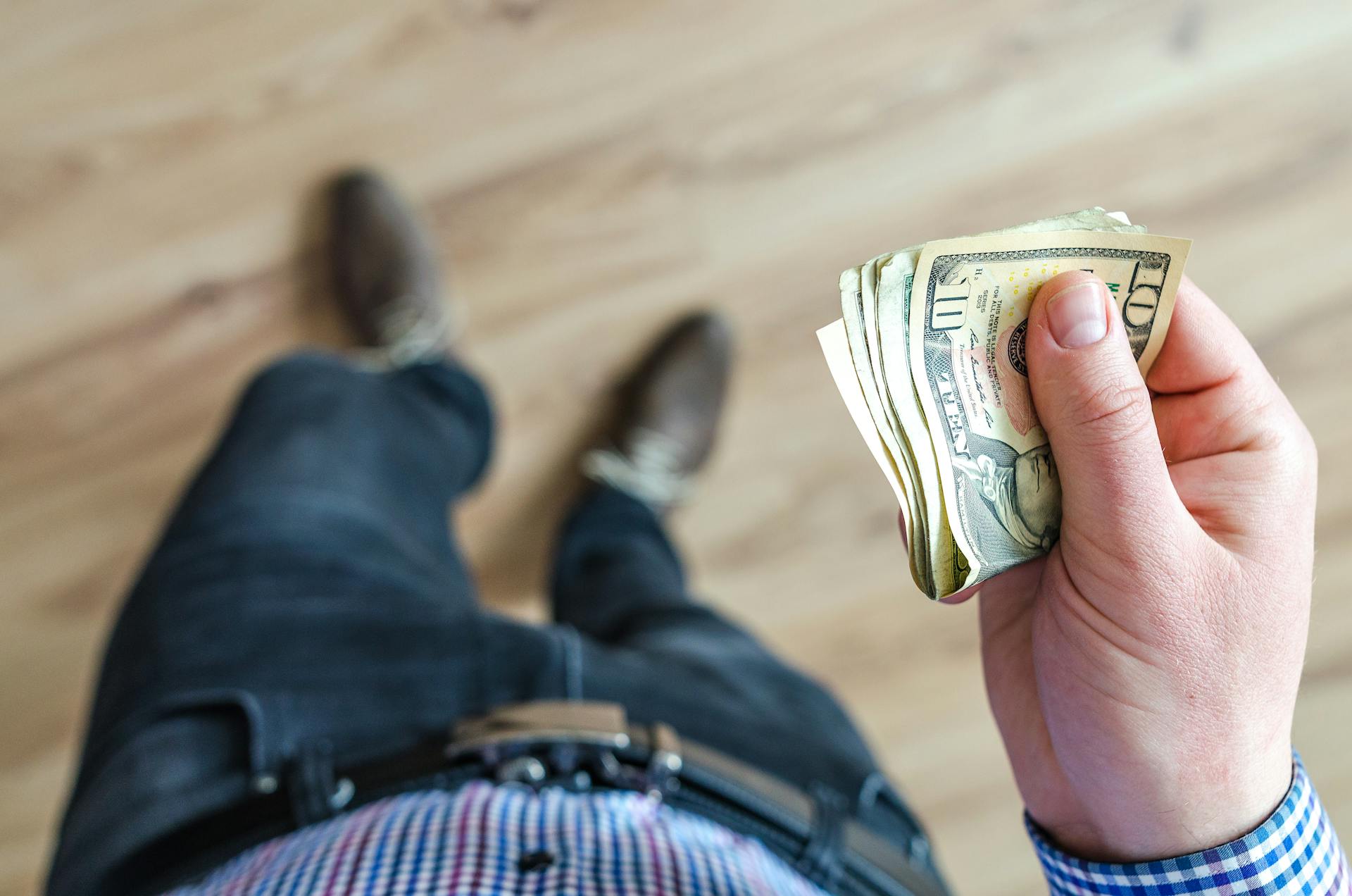 Un homme tenant des billets de banque | Source : Pexels