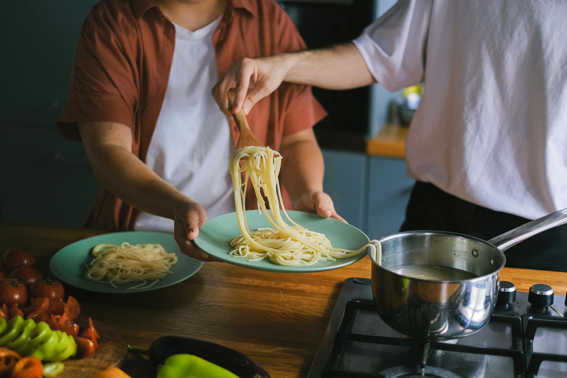 Un homme sortant des spaghettis cuits d'une casserole | Source : Pexels