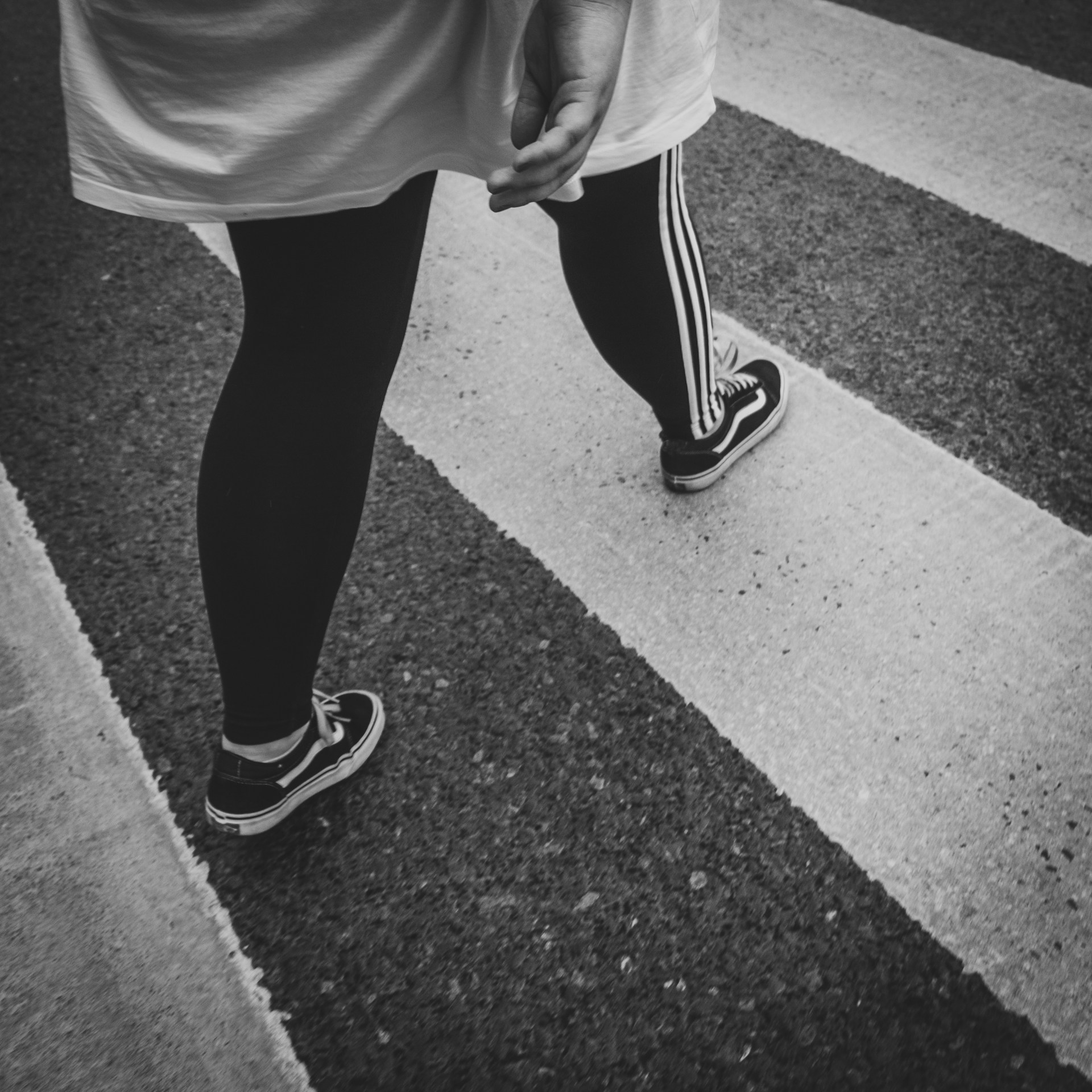 Photo en niveaux de gris d'une personne marchant sur la route | Source : Unsplash