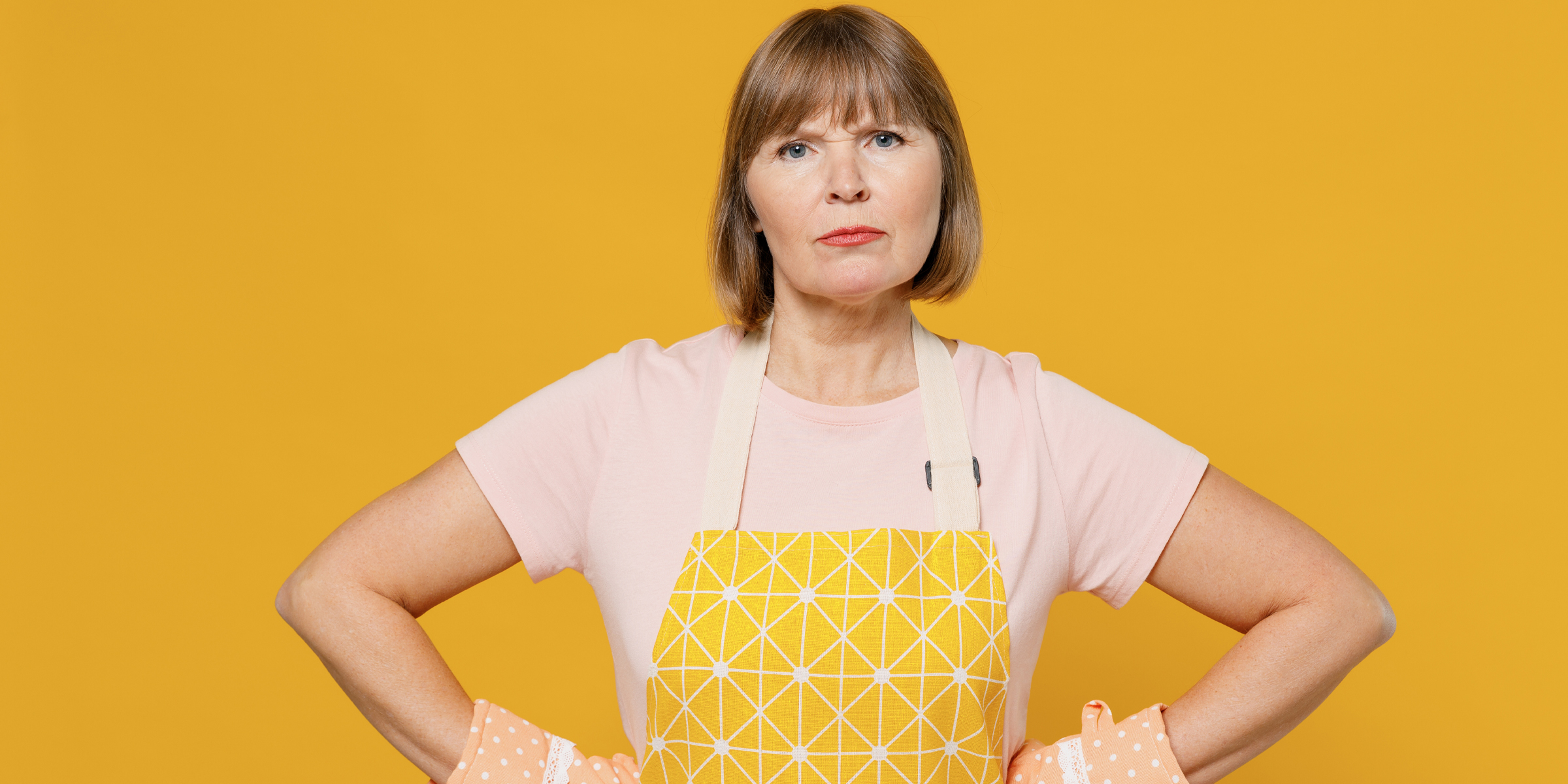 Une femme contrariée portant un tablier et des gants de cuisine | Source : Shutterstock