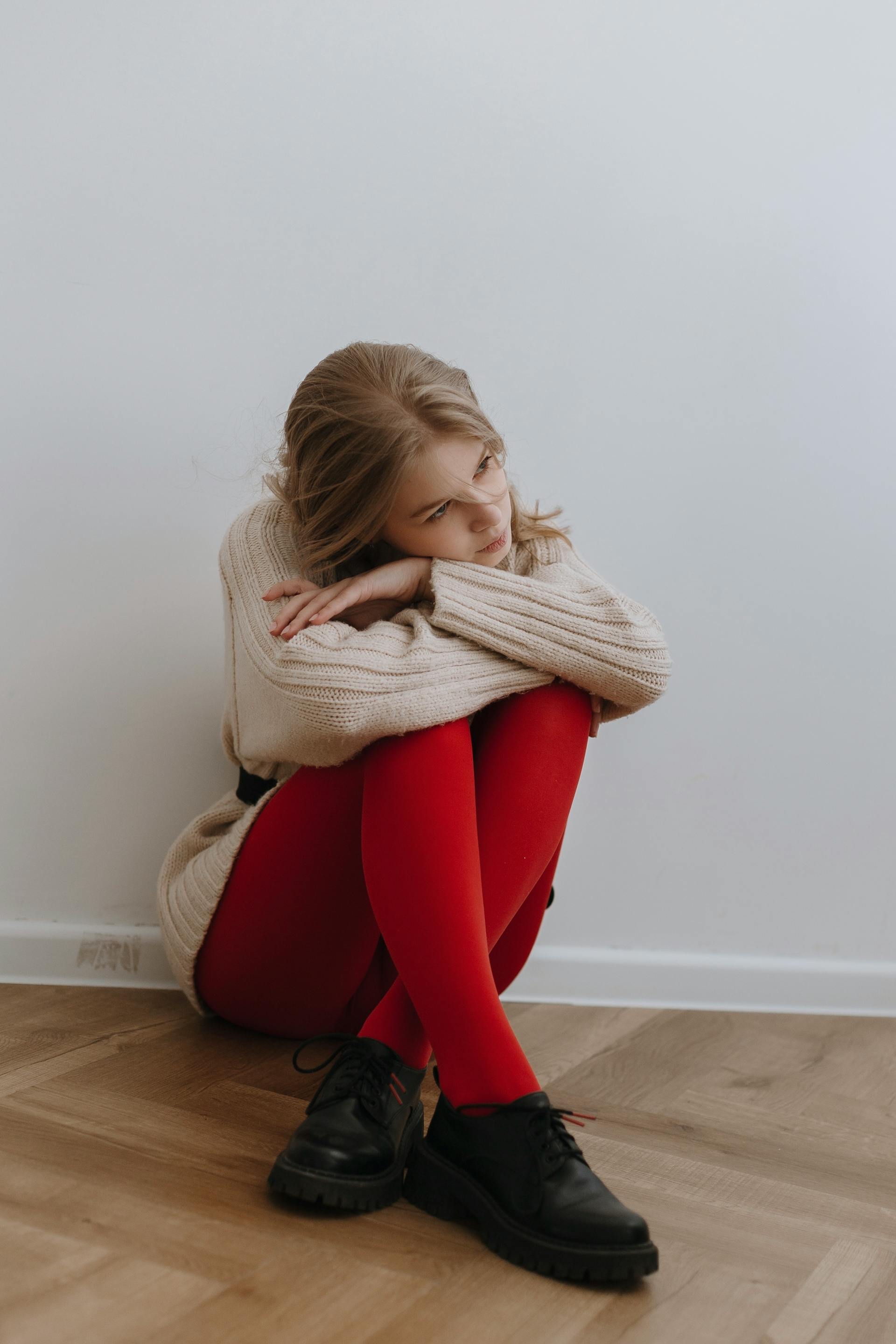 Une femme fatiguée assise par terre près d'un mur | Source : Pexels