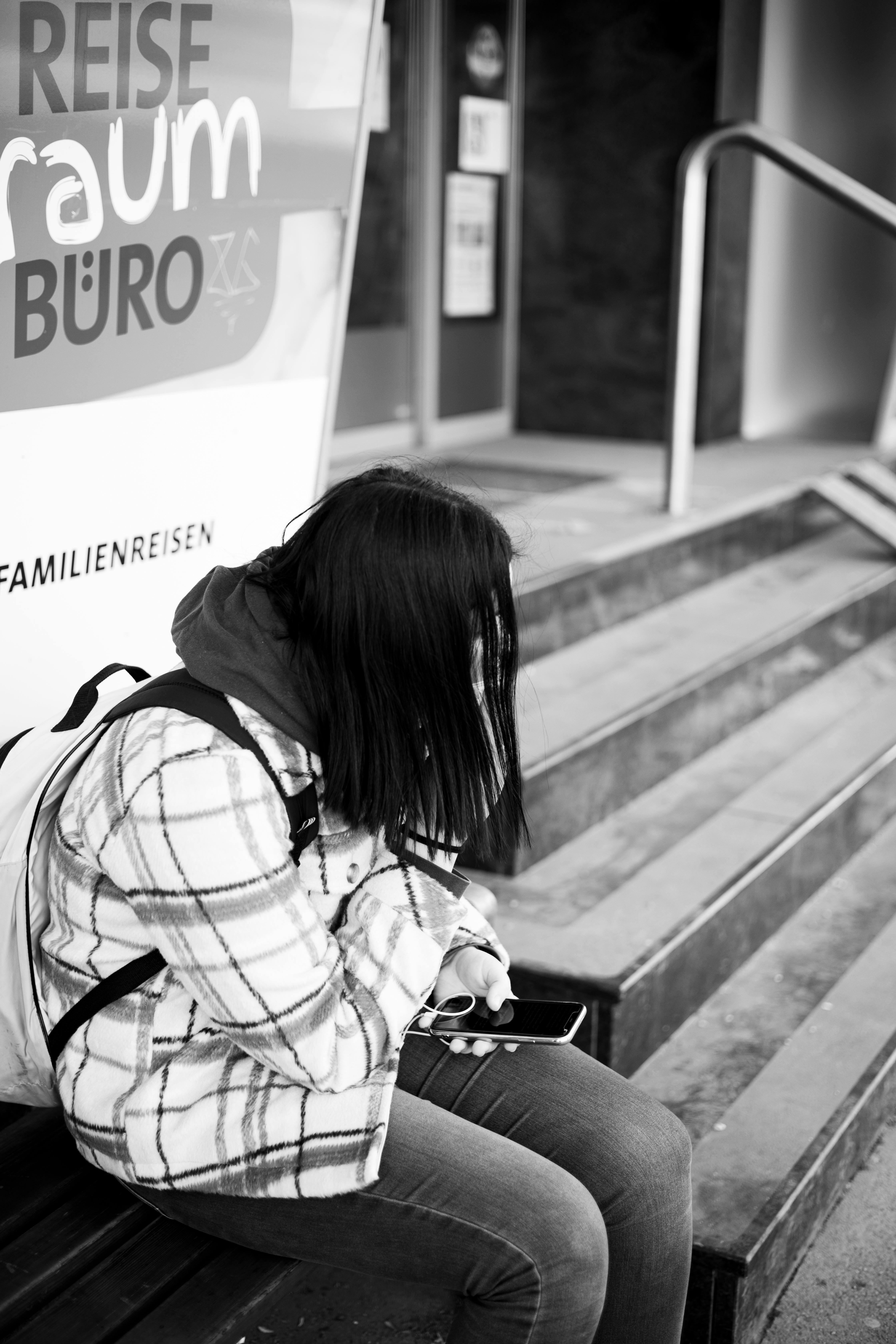 Une fille assise sur un banc et tenant son téléphone | Source : Pexels